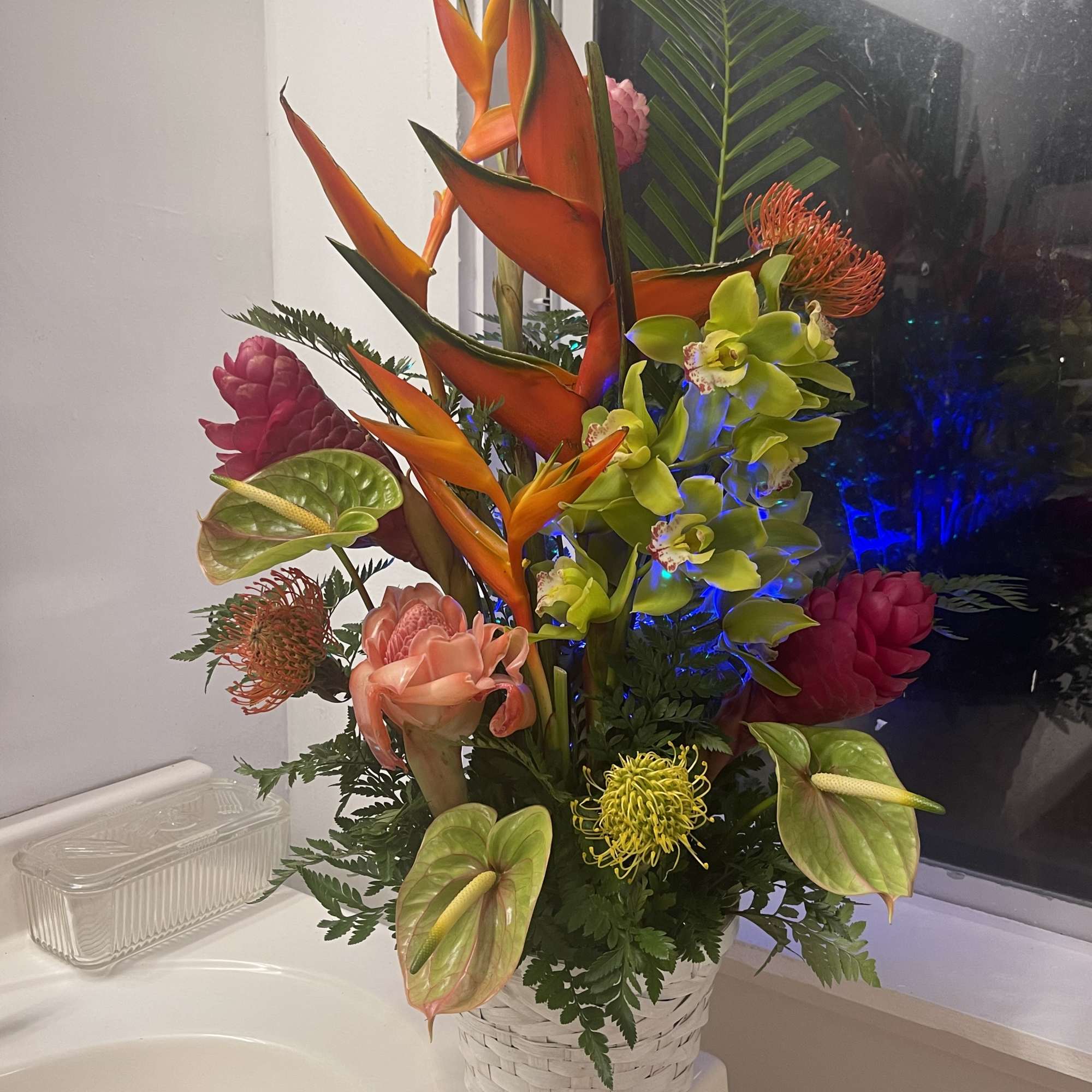 A large beautiful display of tropical flowers in a basket  of