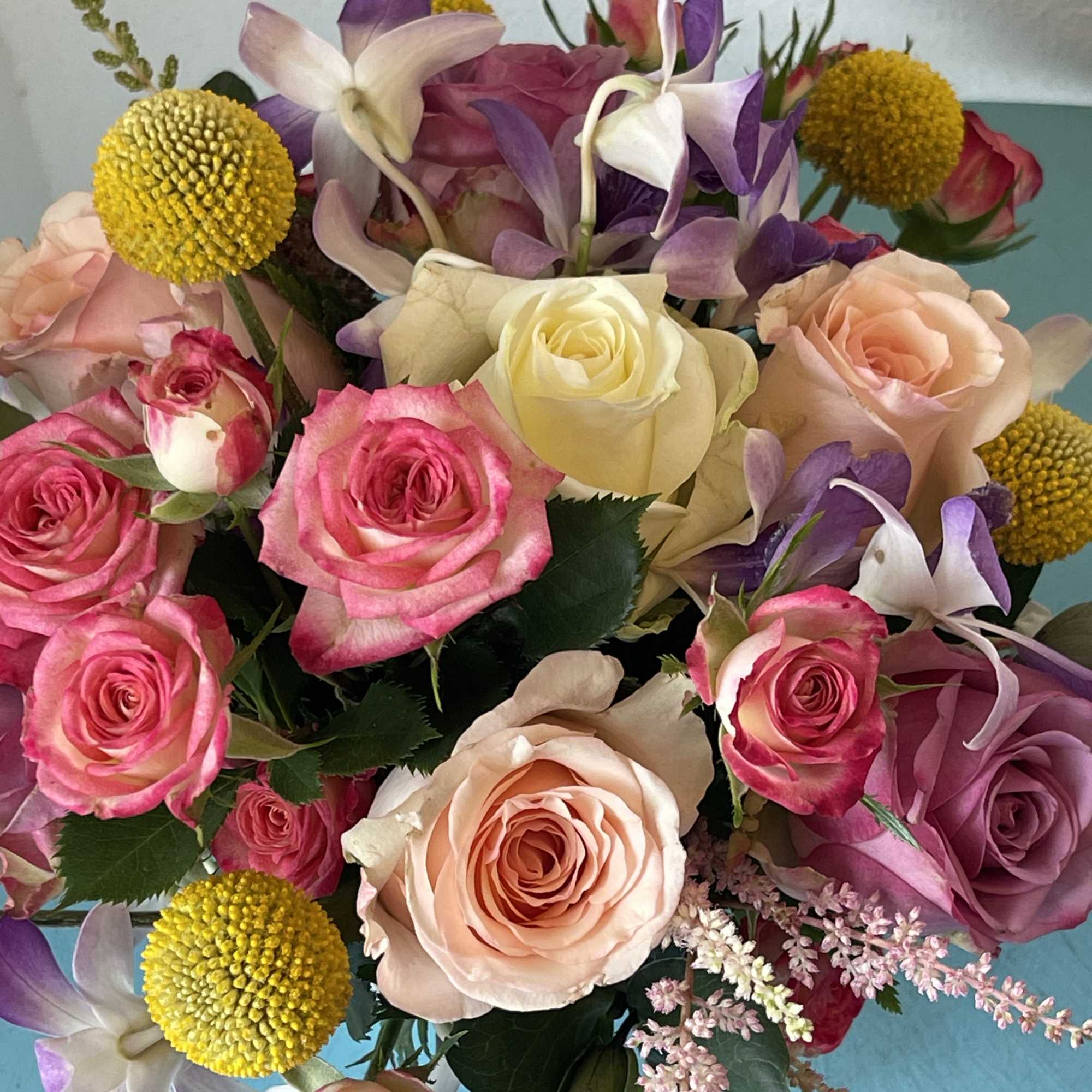 This centerpiece sensation displays a beautiful mix of roses and orchids with