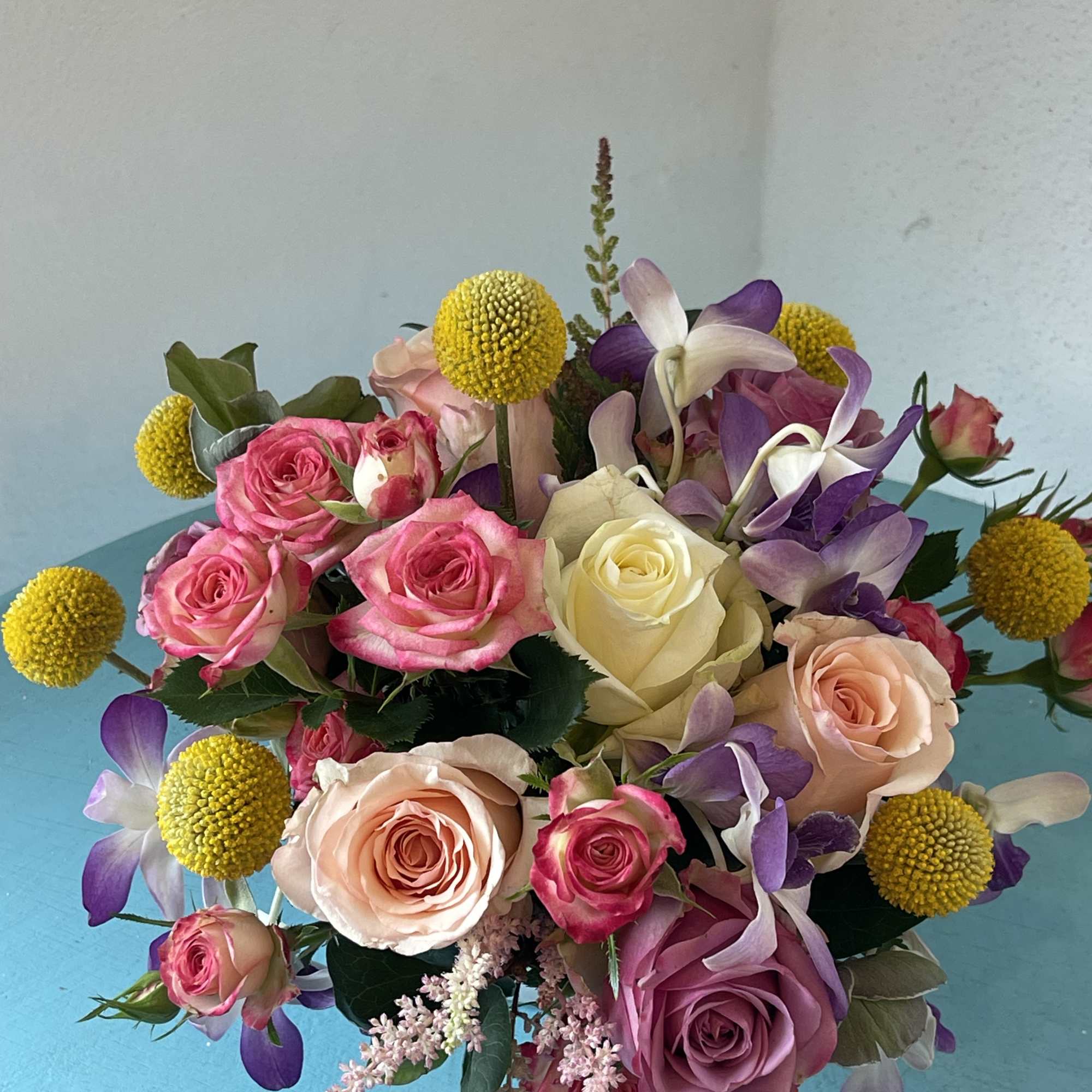 This centerpiece sensation displays a beautiful mix of roses and orchids with