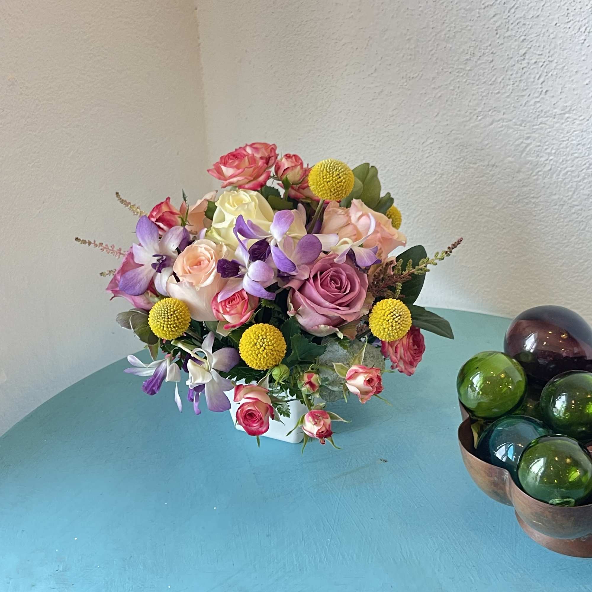 This centerpiece sensation displays a beautiful mix of roses and orchids with