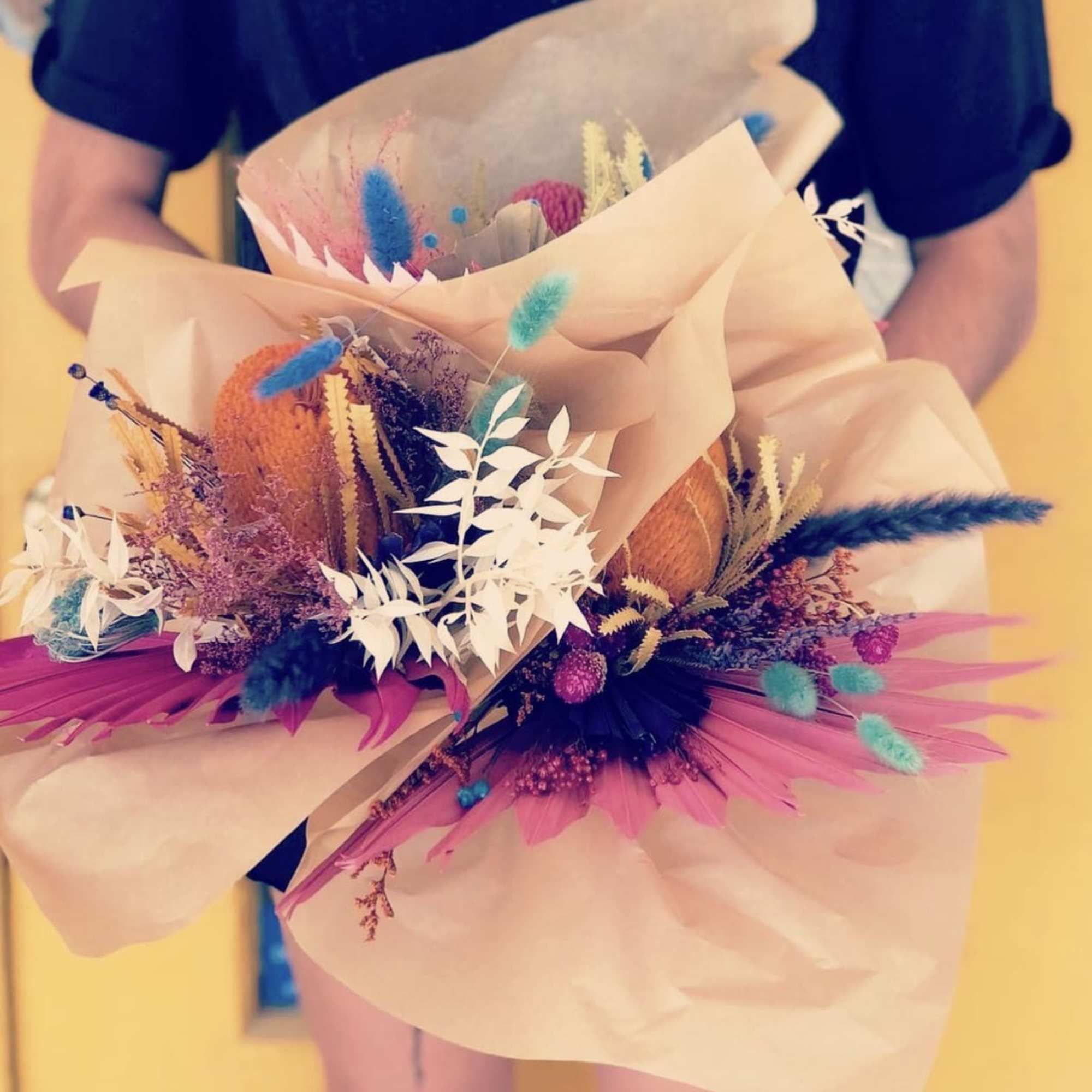 A colorful display of three #3 preserved floral bouquets 