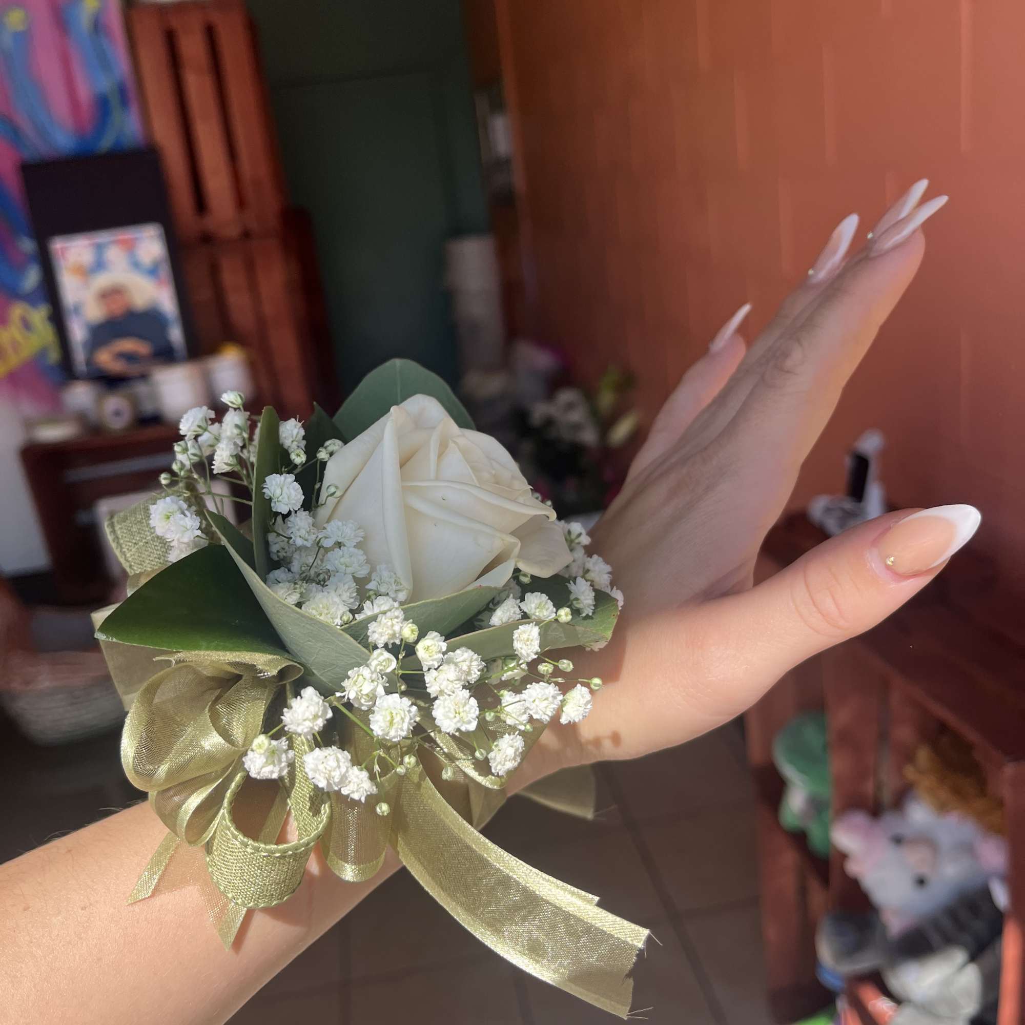 Small white rose corsage with baby's breath and gold ribbon