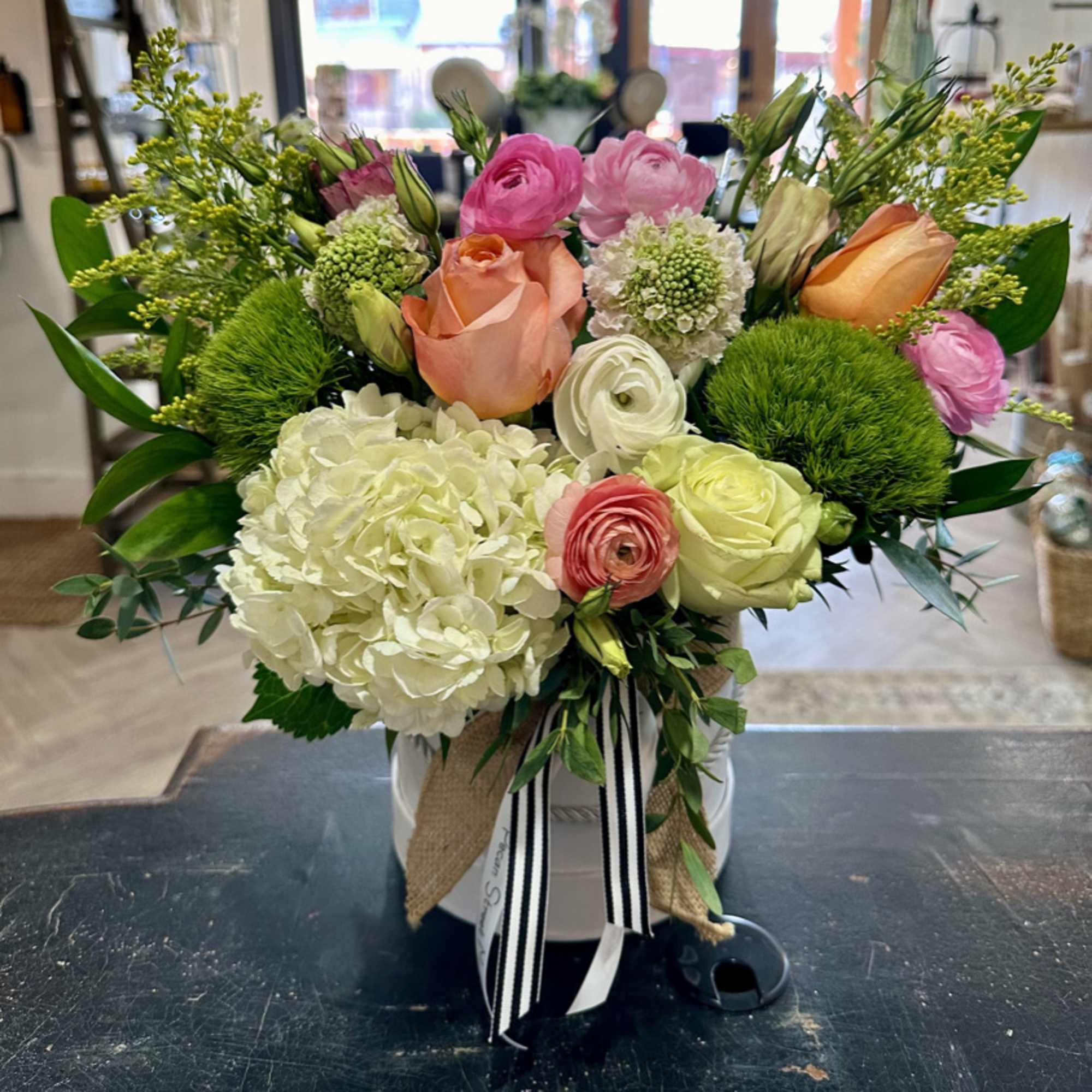 Mixed bouquet in a white hatbox with pink, peach, and white blooms