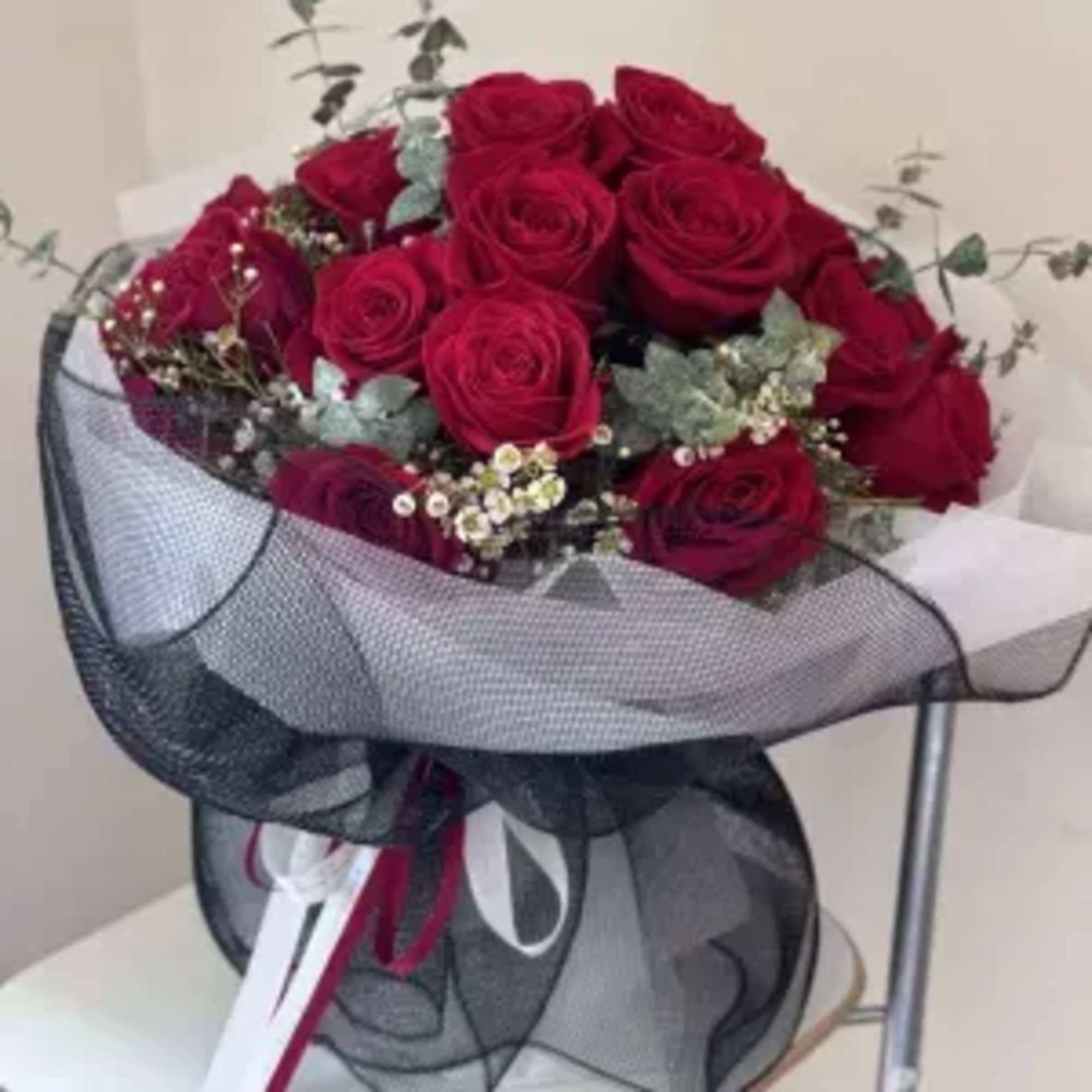 Imagine a stunning bouquet comprised of a dozen deep red roses, each