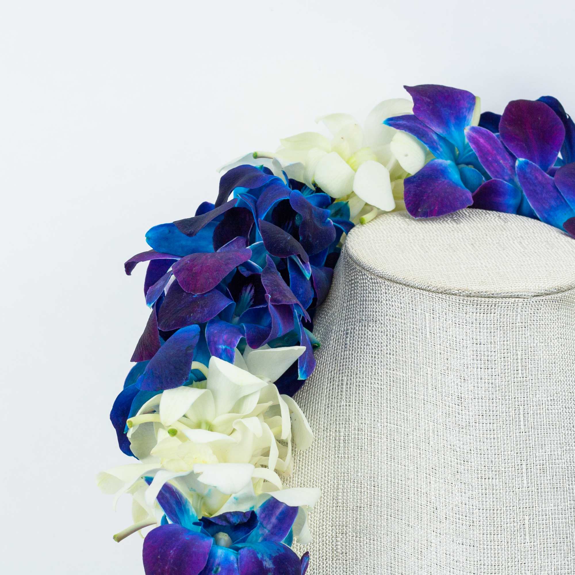 Blue, purple, and white flower lei draped over a mannequin bust