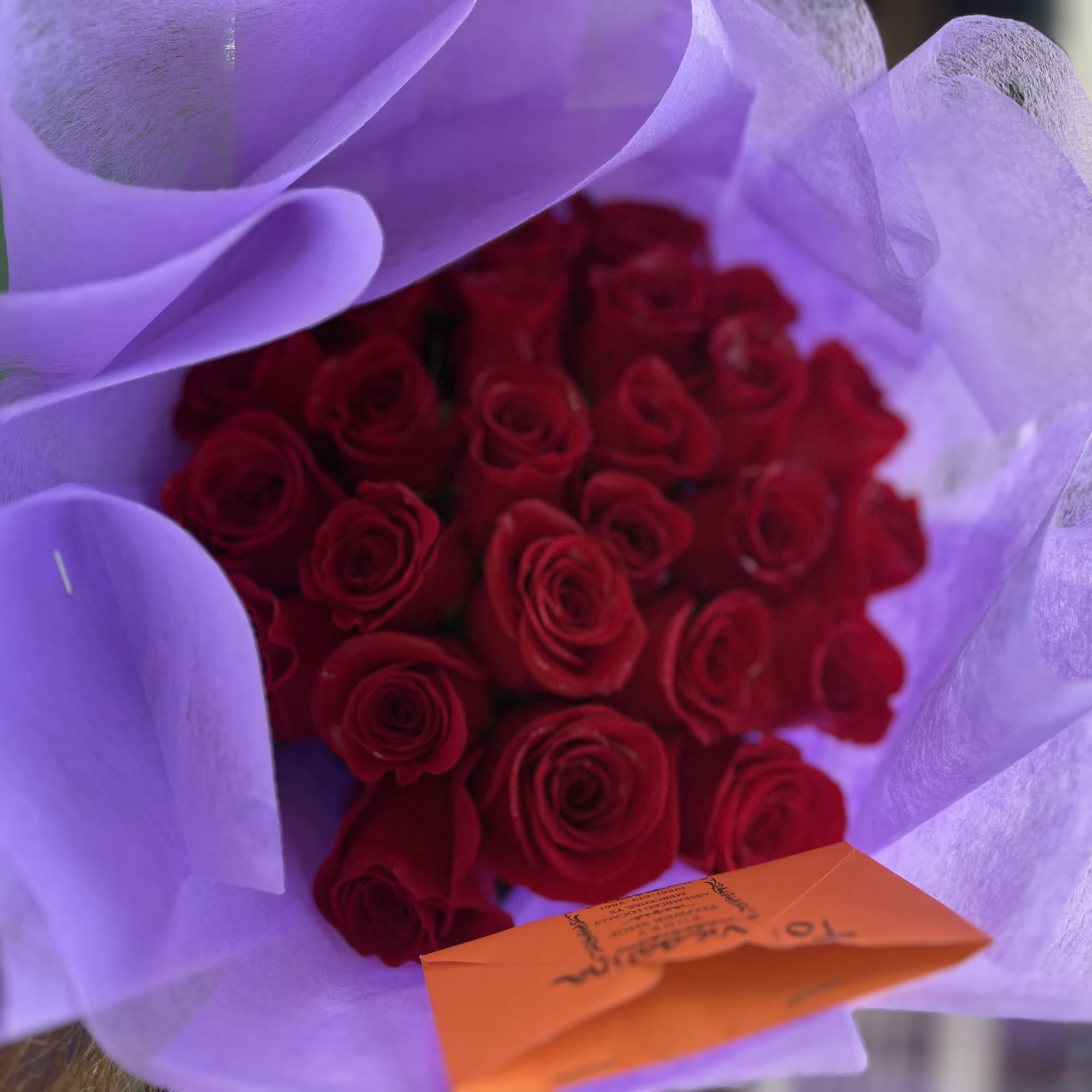 Bouquet of red roses wrapped in lavender paper