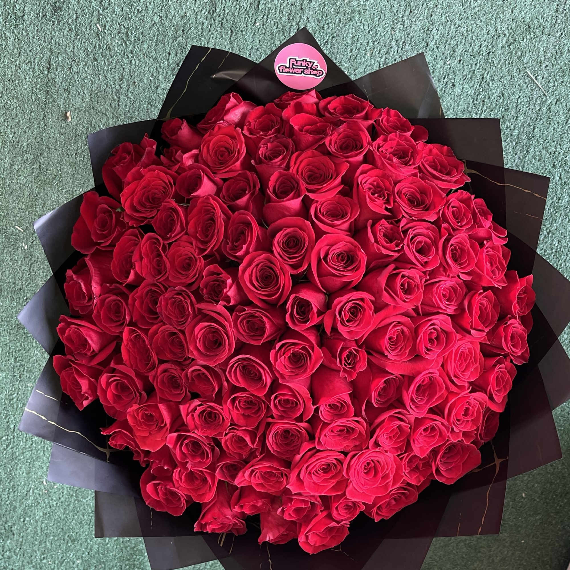 Large bouquet of red roses wrapped in black paper