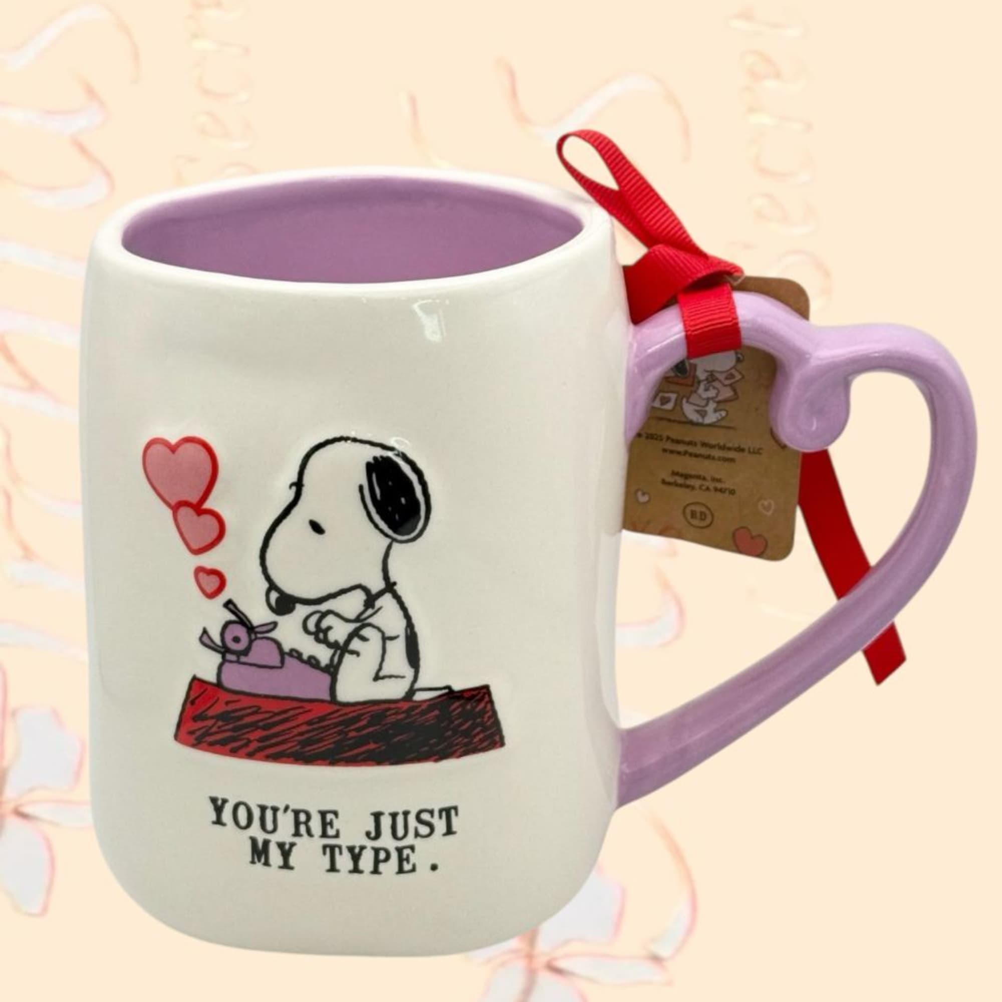 Snoopy mug with a heart design and red ribbon tag