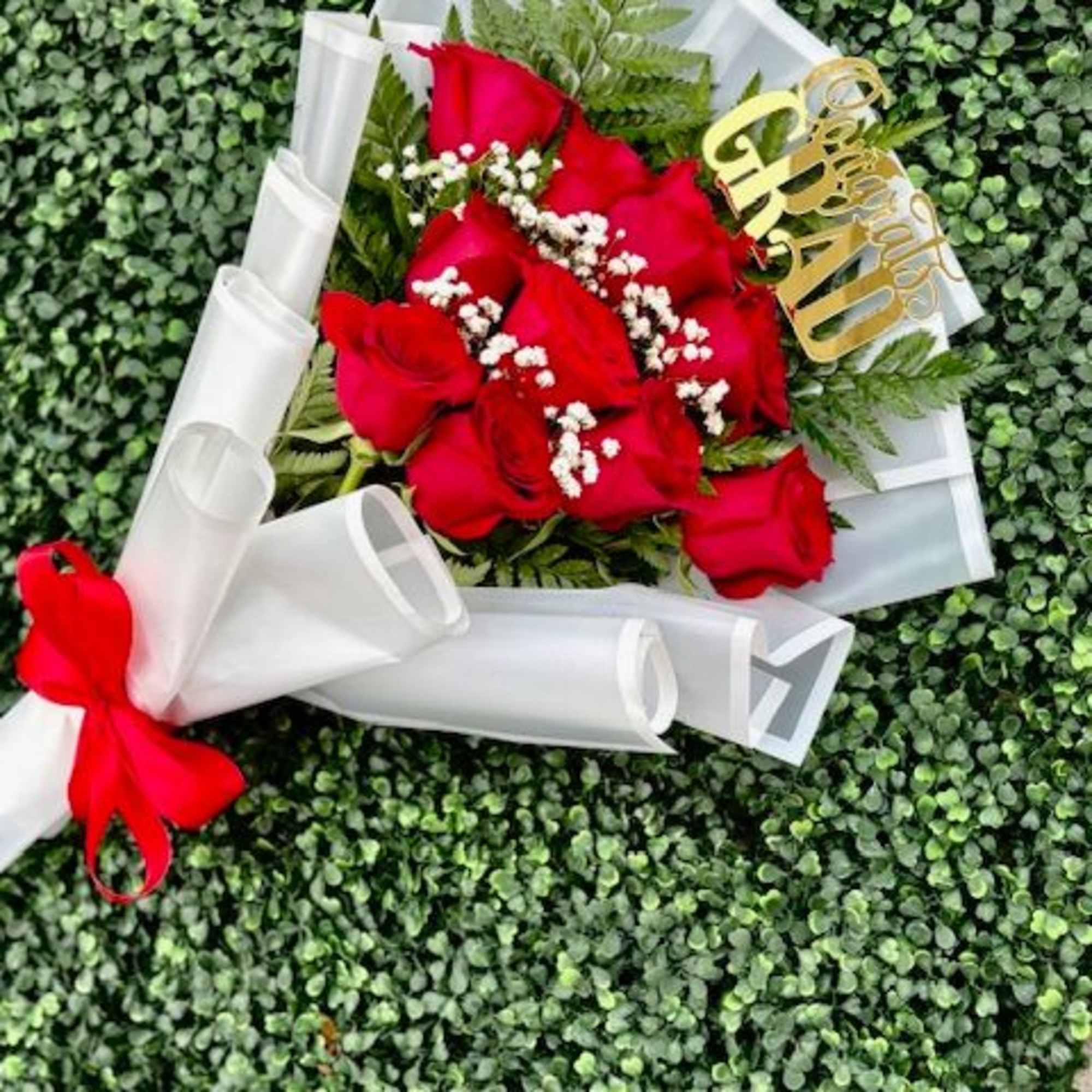 Vivid red roses take center stage in this Congrats Grad bouquet, making