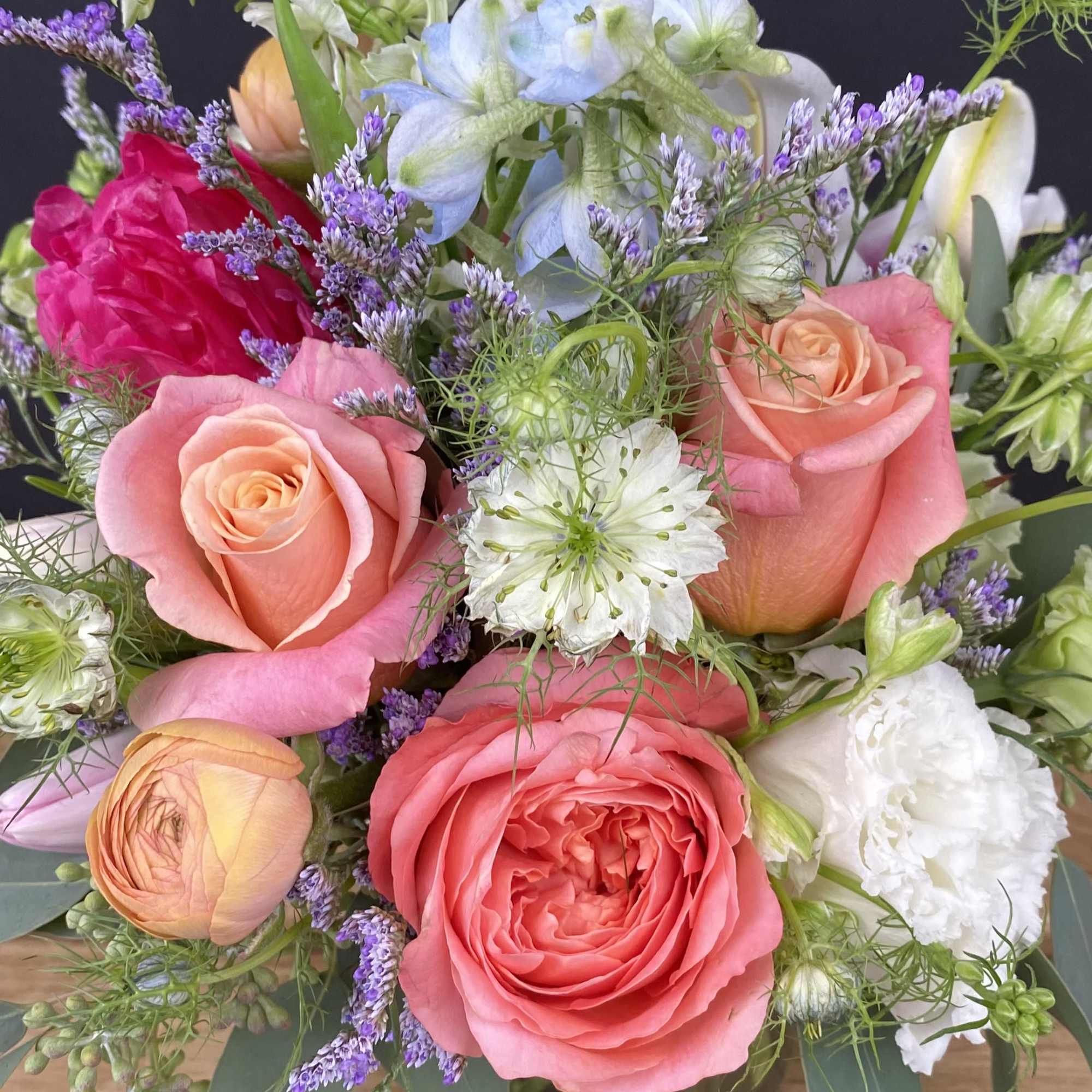 This arrangement includes a sweet mix of Garden Roses, Peonies, Lisianthus, Delphinium