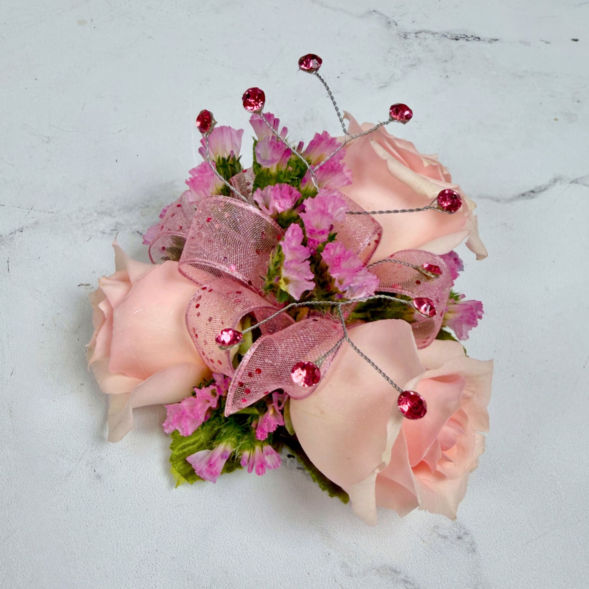 A cluster of petite blush pink spray roses accented with tiny pink