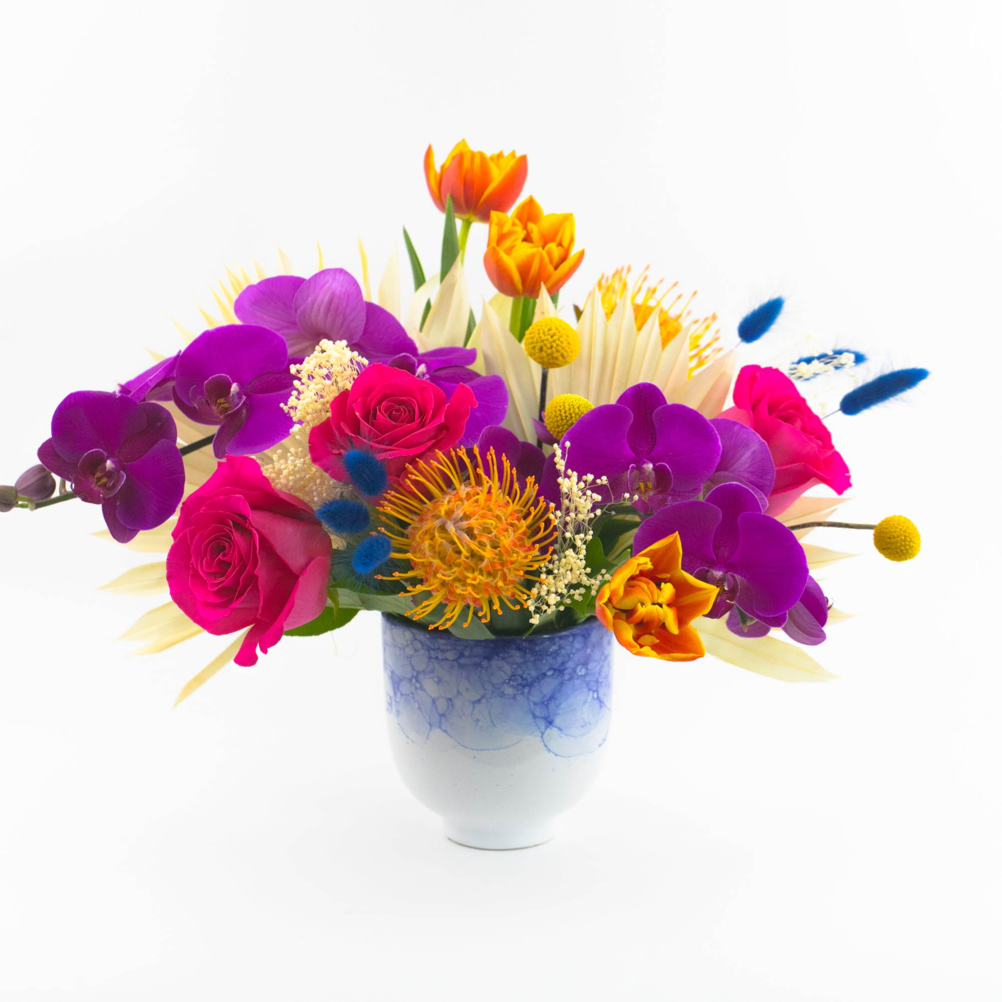 Colorful bouquet of roses and orchids in a blue ceramic vase