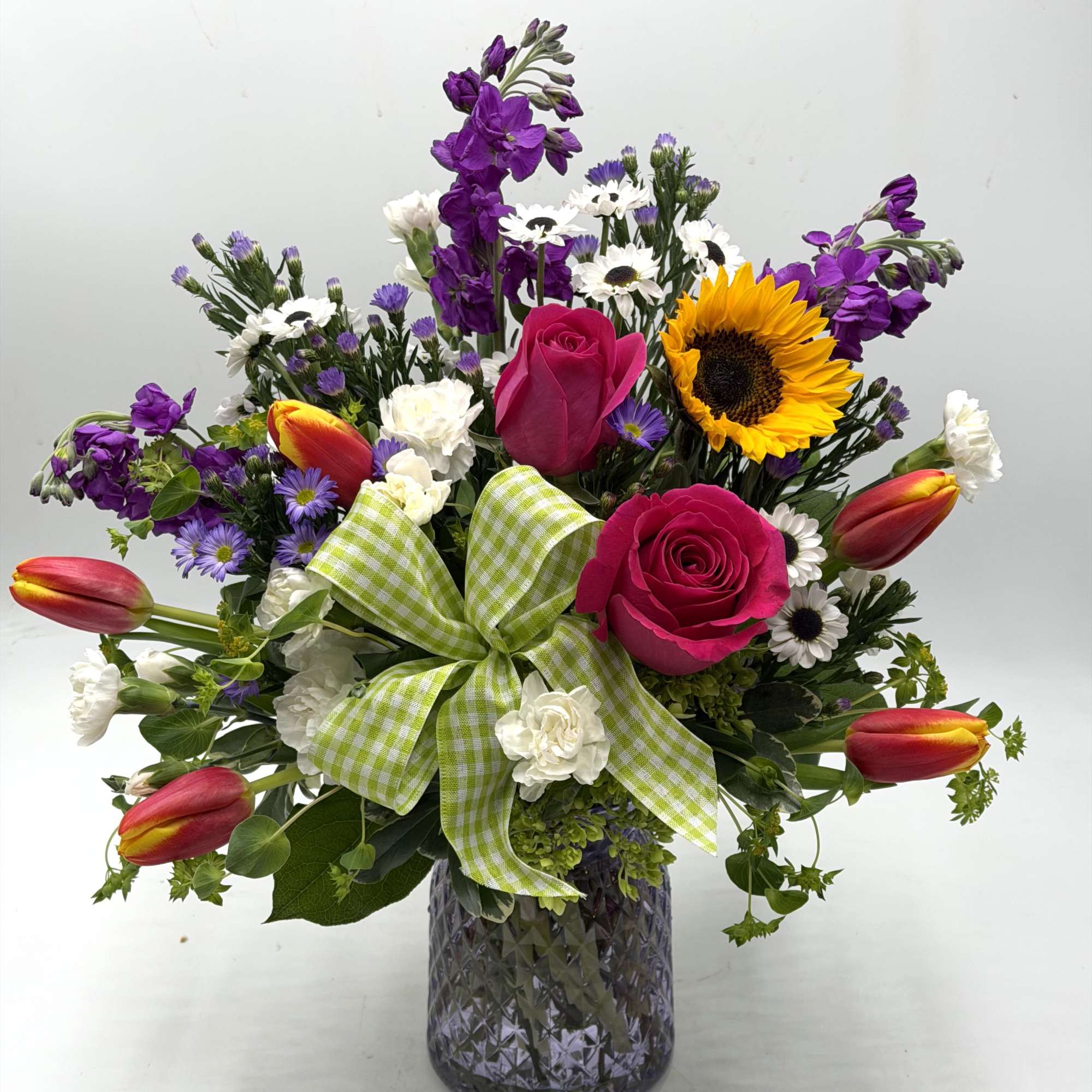 Bright &amp; Uplifting, this lively garden-style arrangement blends bold pink roses, sunny