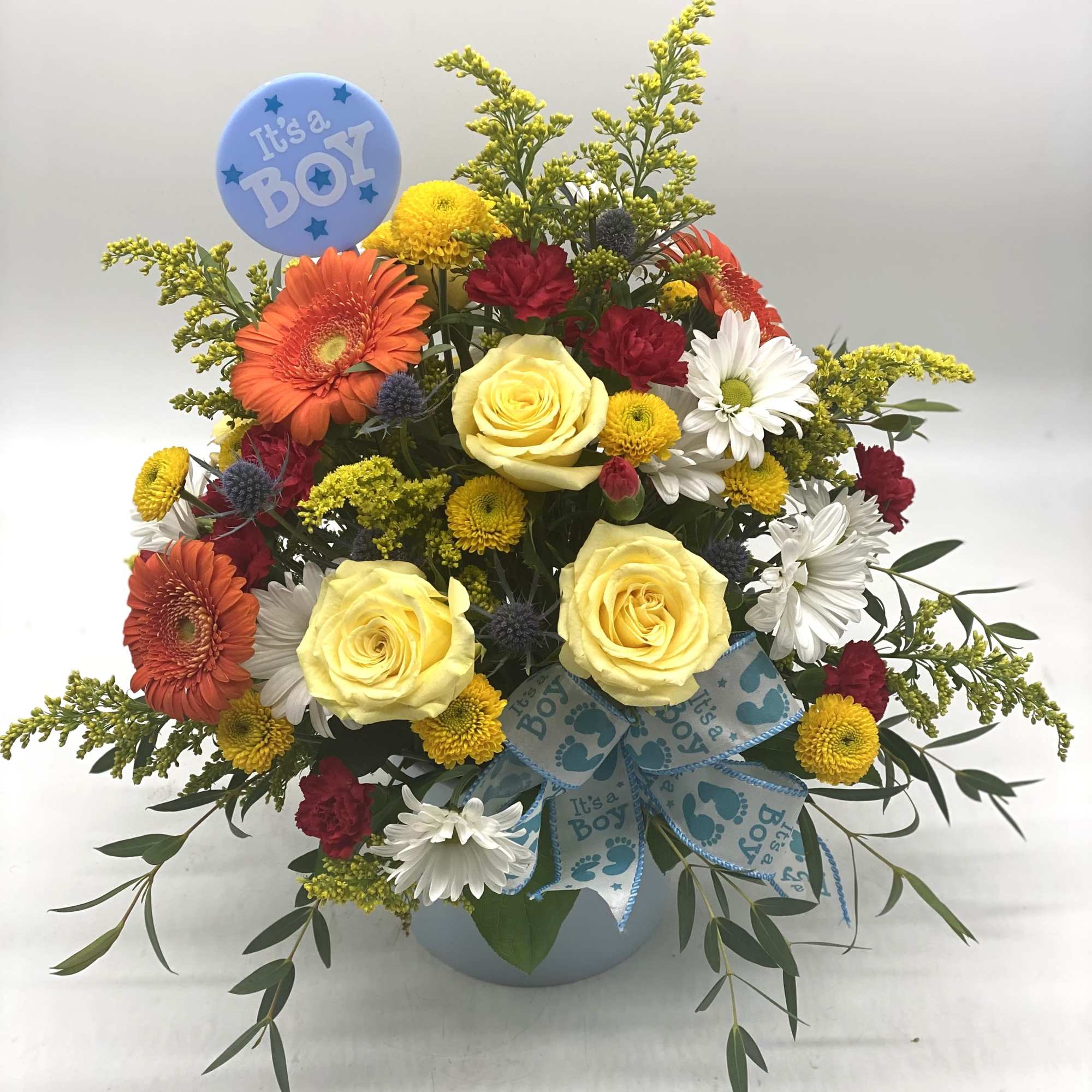 Mixed bouquet in a vase with a blue "It's a Boy" pick and ribbon