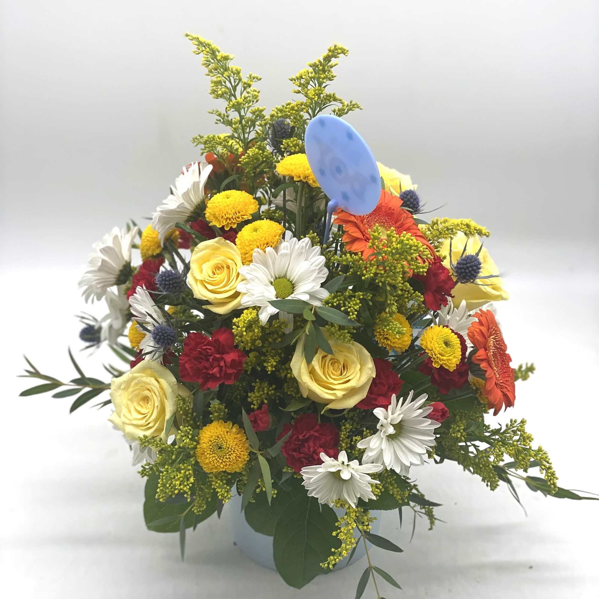 Mixed bouquet of roses, daisies, and gerbera daisies in a vase
