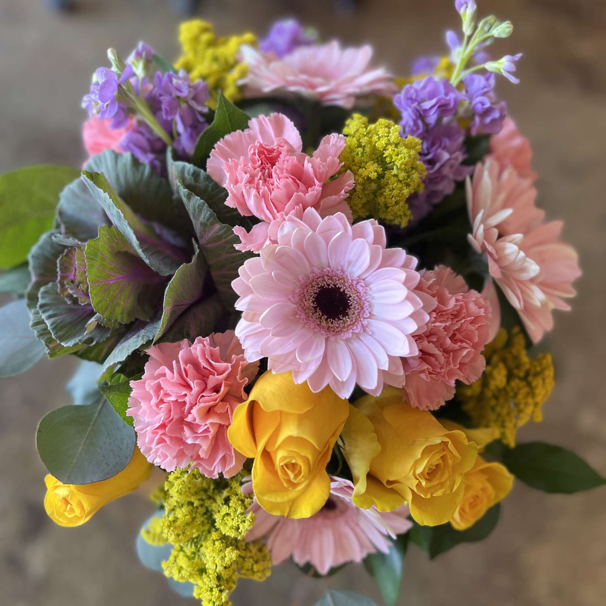 Bouquet of pink gerbera daisies, yellow roses, and carnations