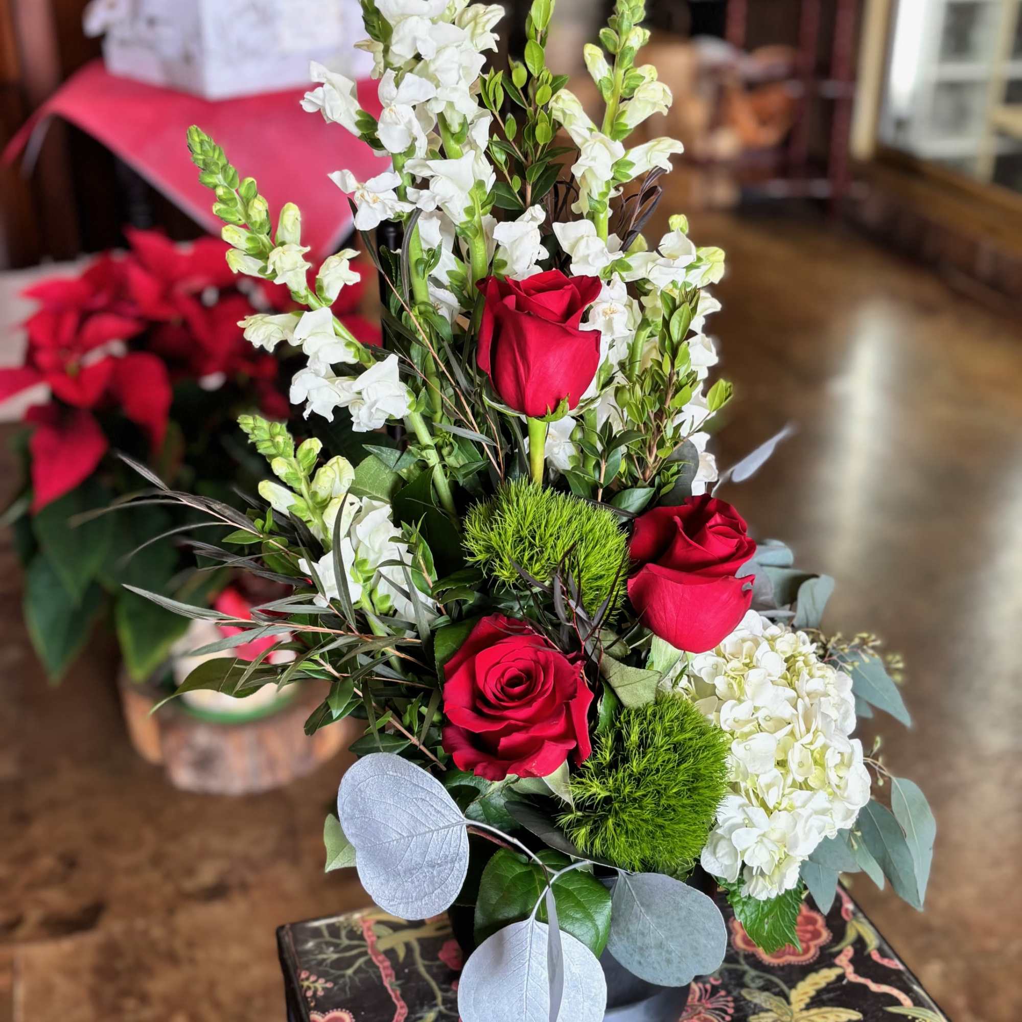 Red roses and white snapdragons in a black vase