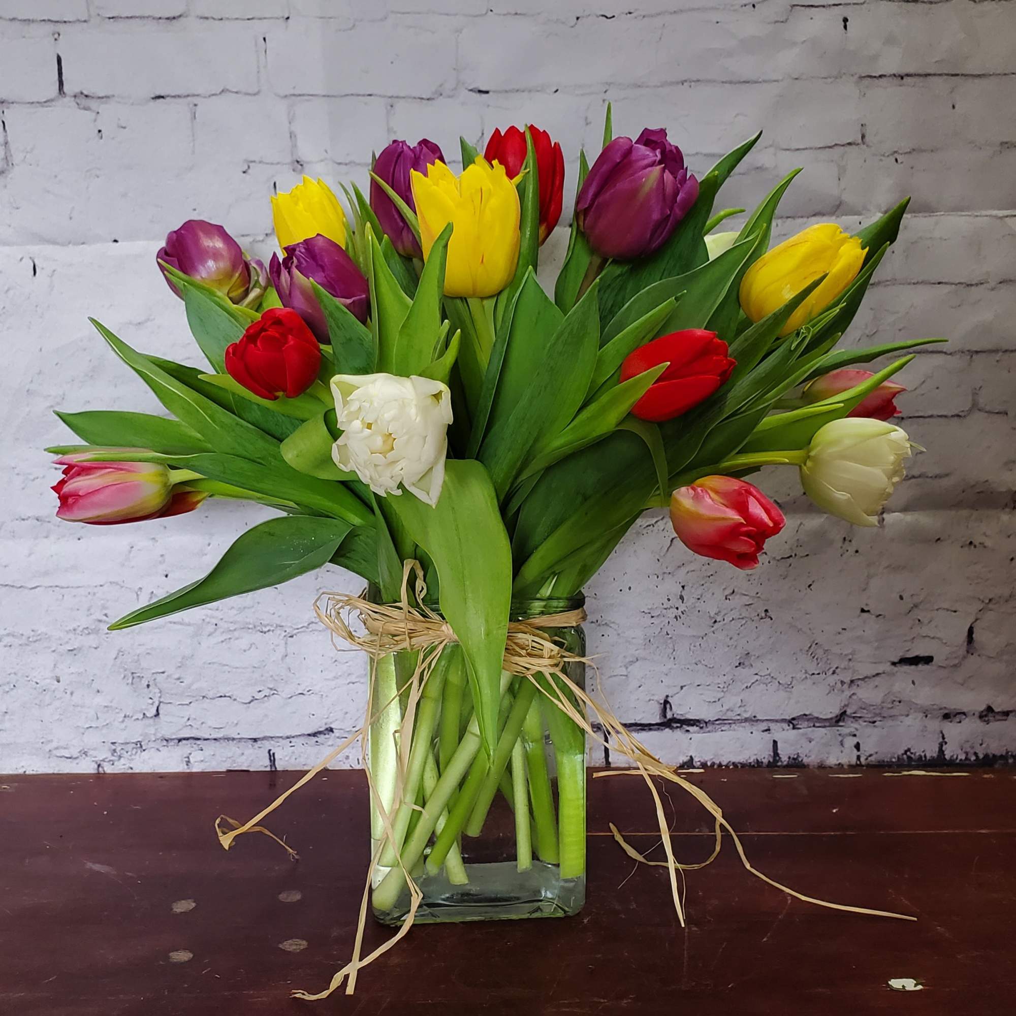 Bouquet of multicolored tulips in a clear glass vase