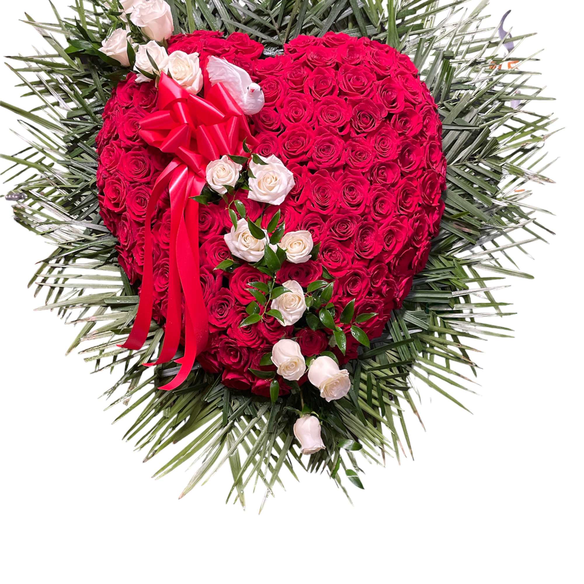 Heart-shaped rose arrangement with a red ribbon and palm fronds