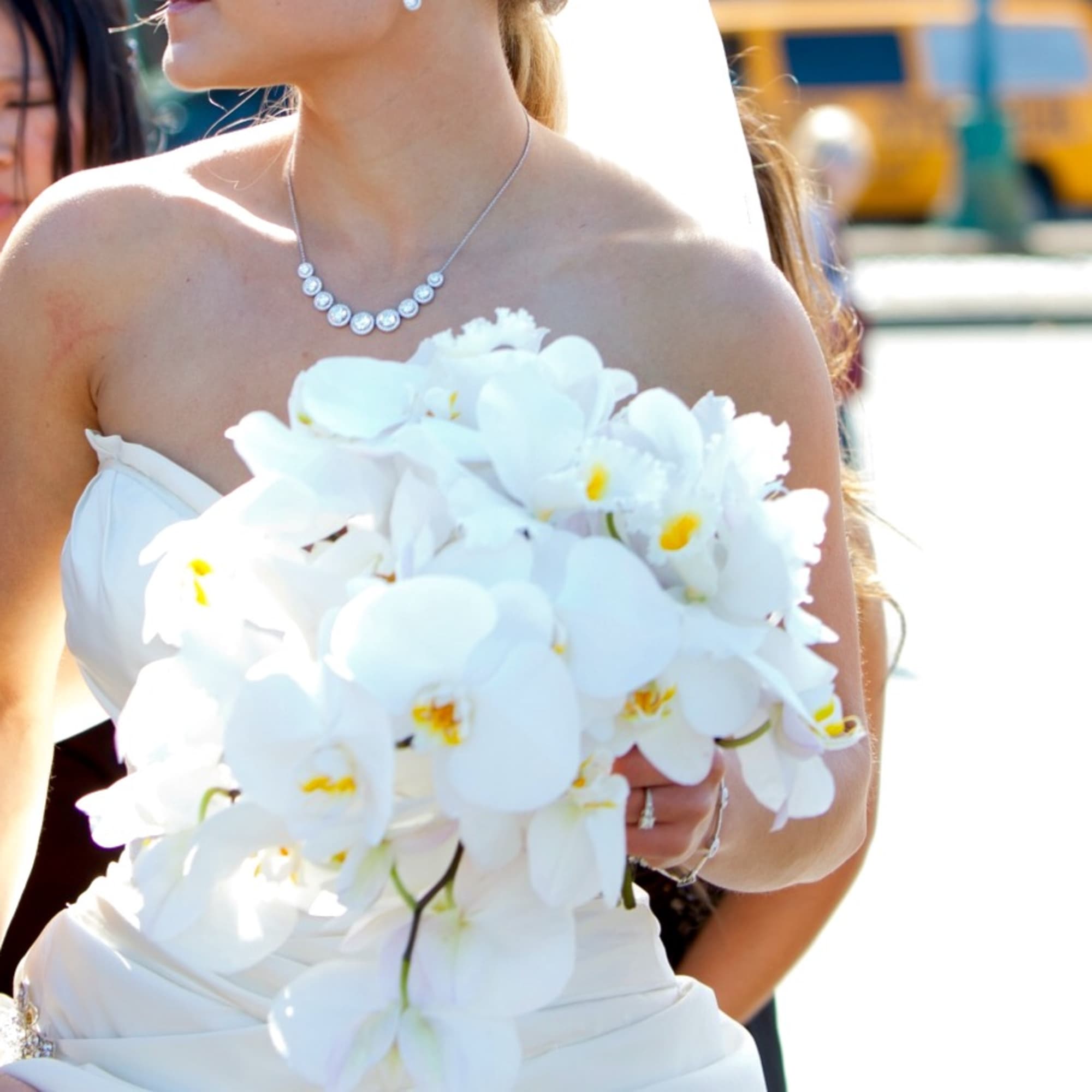 Bride holding a white orchid bouquet