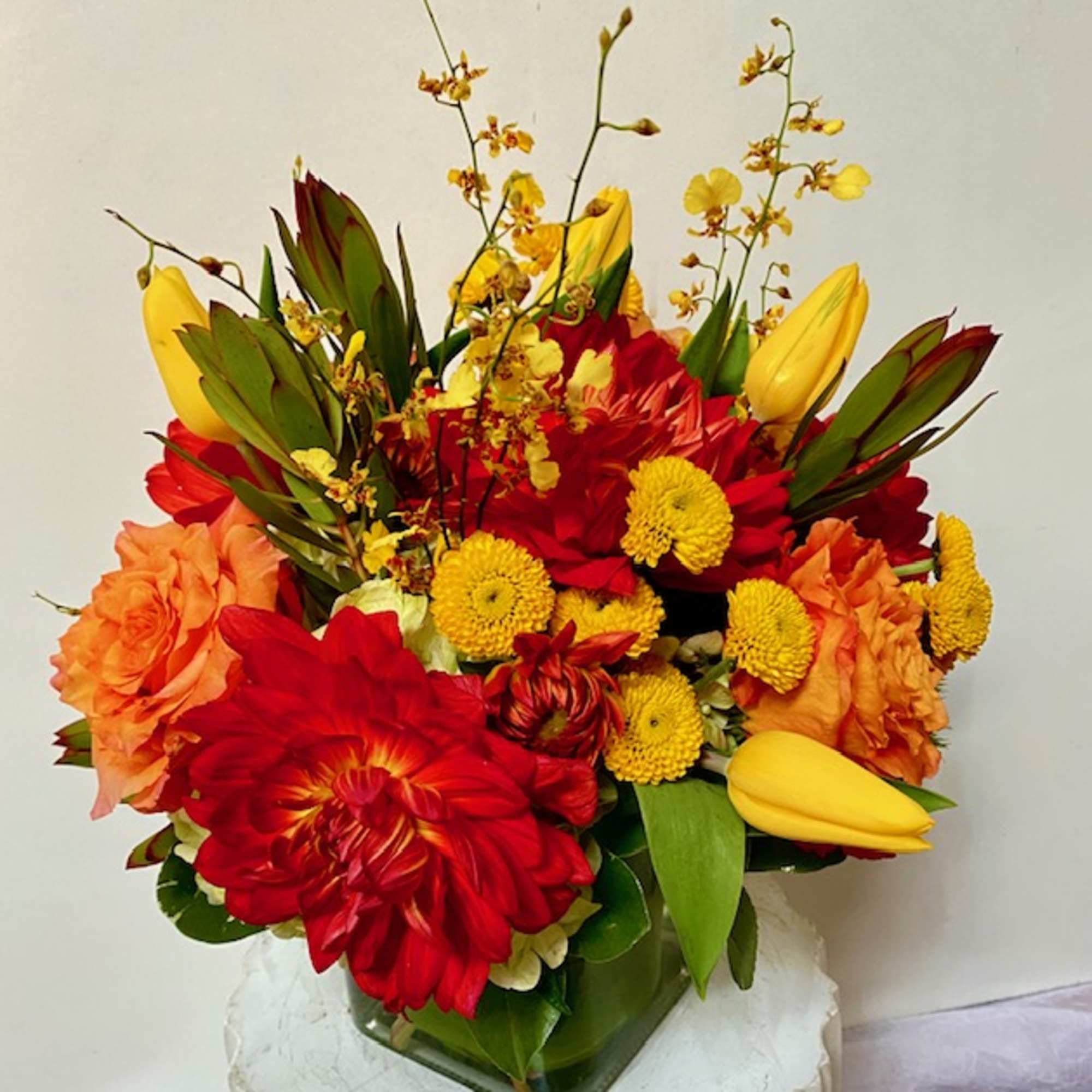 Bright red, orange, and yellow mixed bouquet in a glass vase