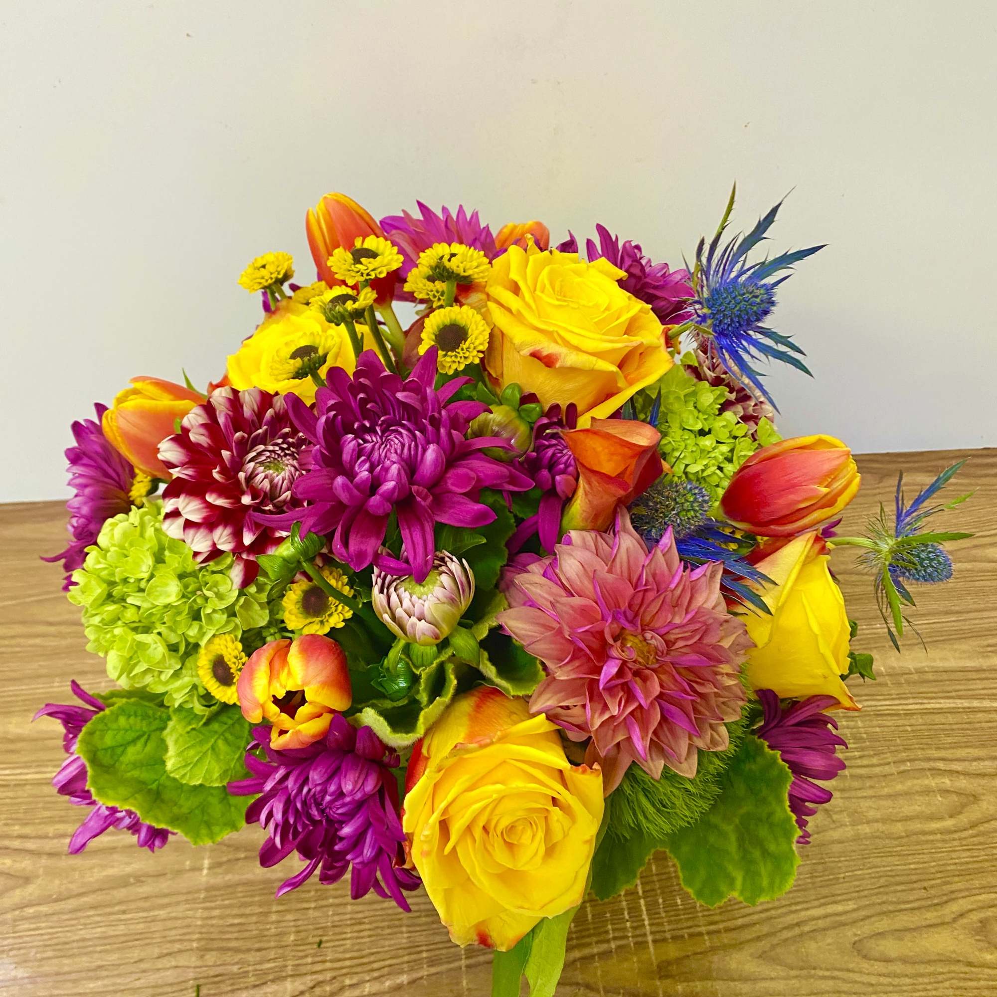 Bright mixed bouquet with yellow roses, purple mums, and orange tulips