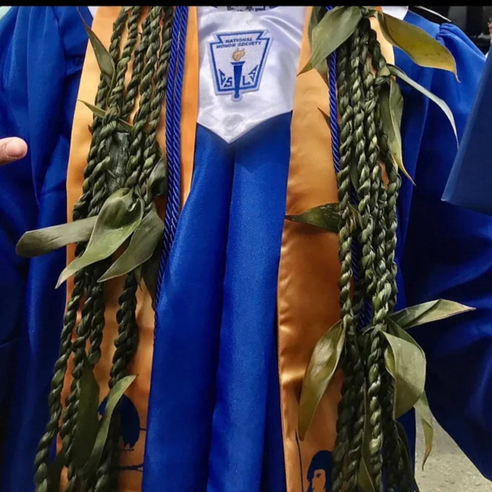 Graduation gown with braided green leis and honor cords