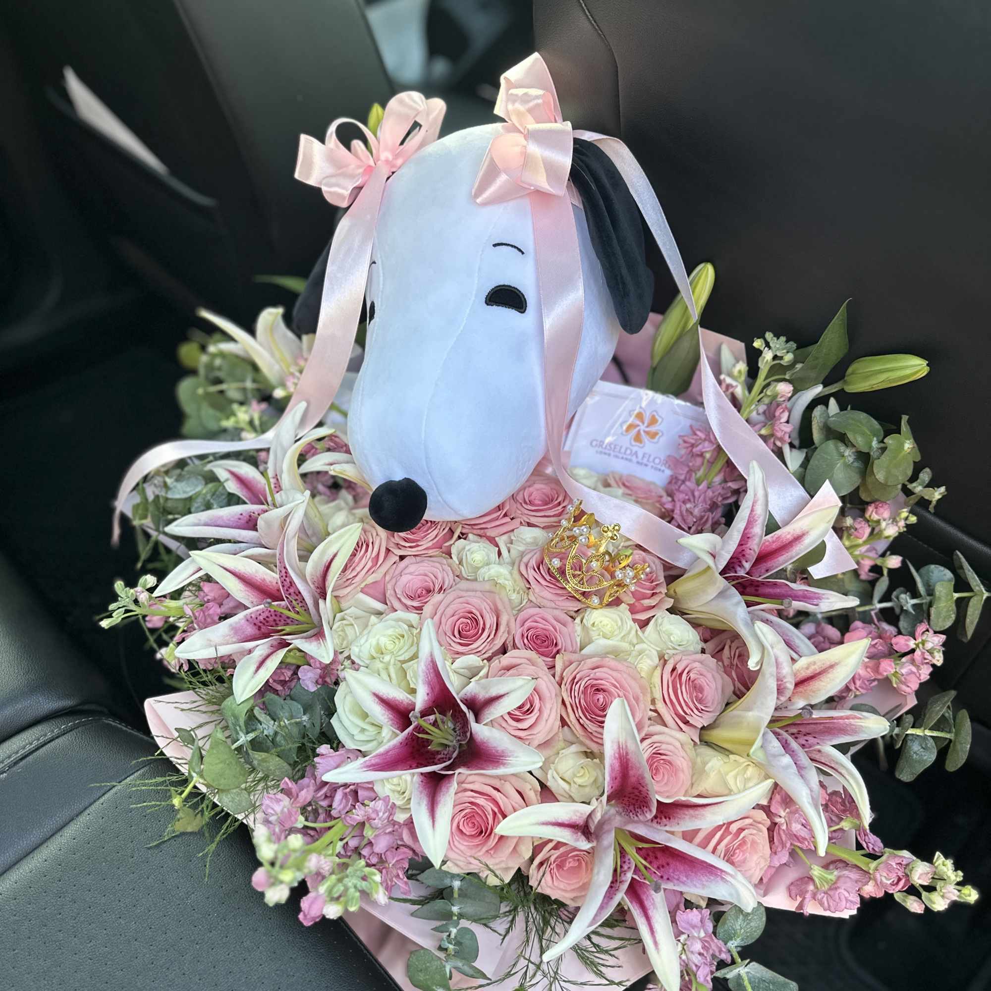 Pink rose bouquet with lilies and a plush dog centerpiece