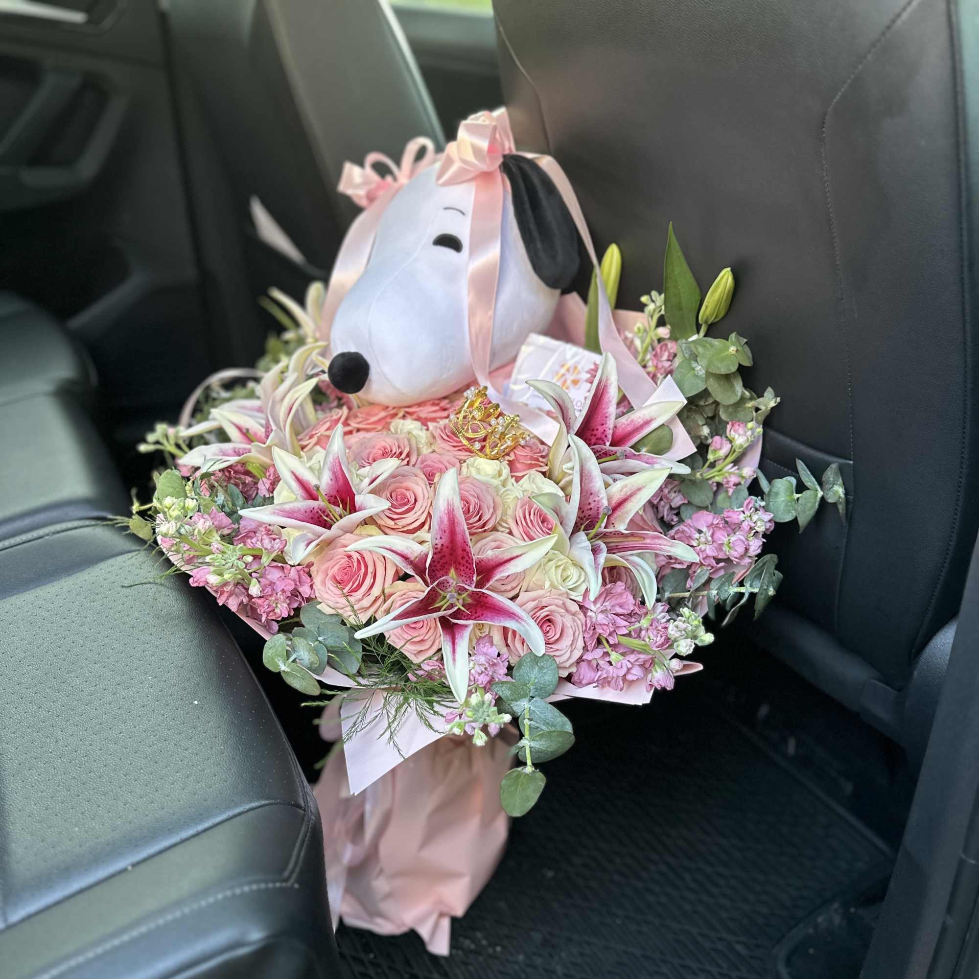 Pink rose bouquet with lilies and a plush dog head topper
