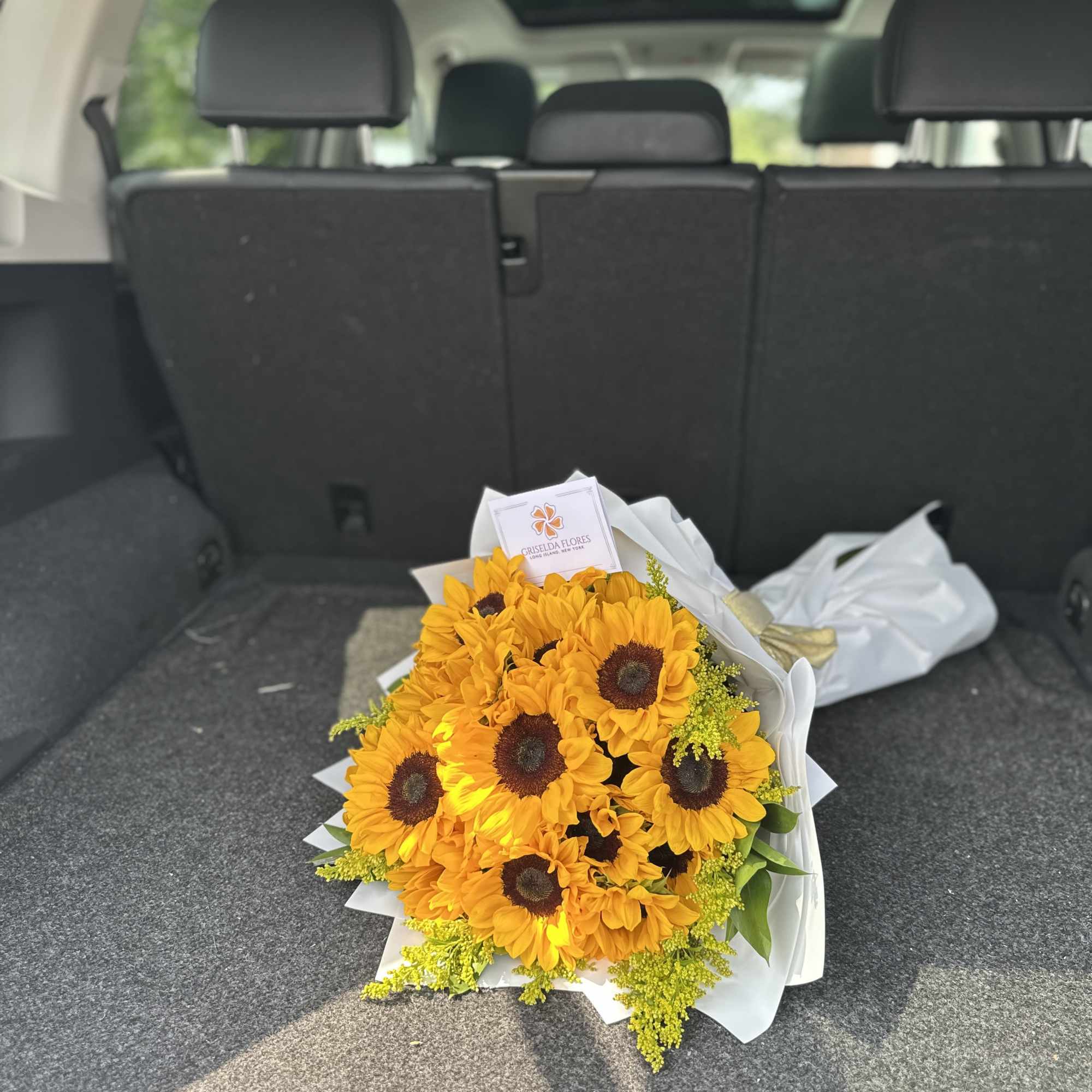 Bouquet of bright yellow sunflowers wrapped in white paper