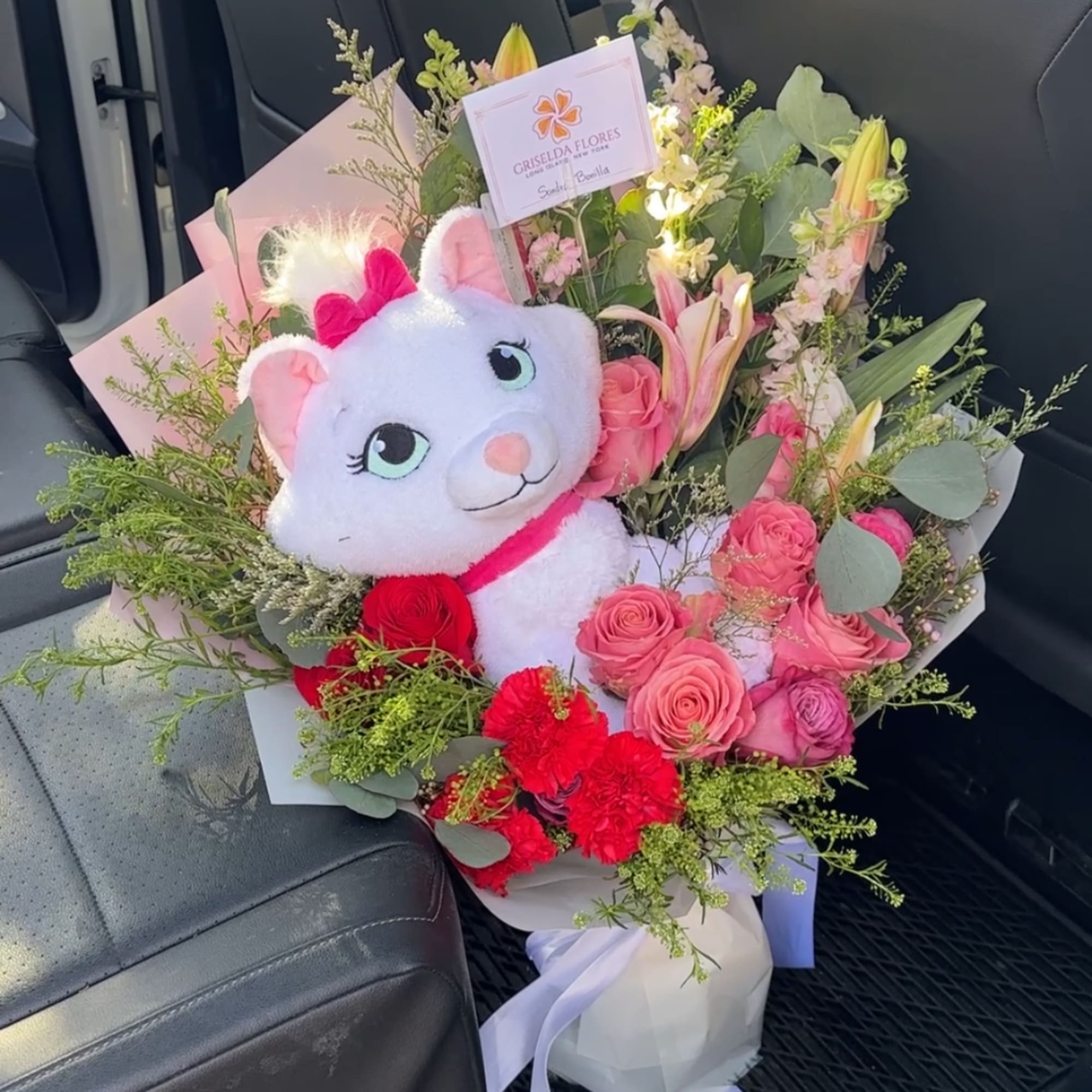 Bouquet of pink roses and lilies with a plush cat toy