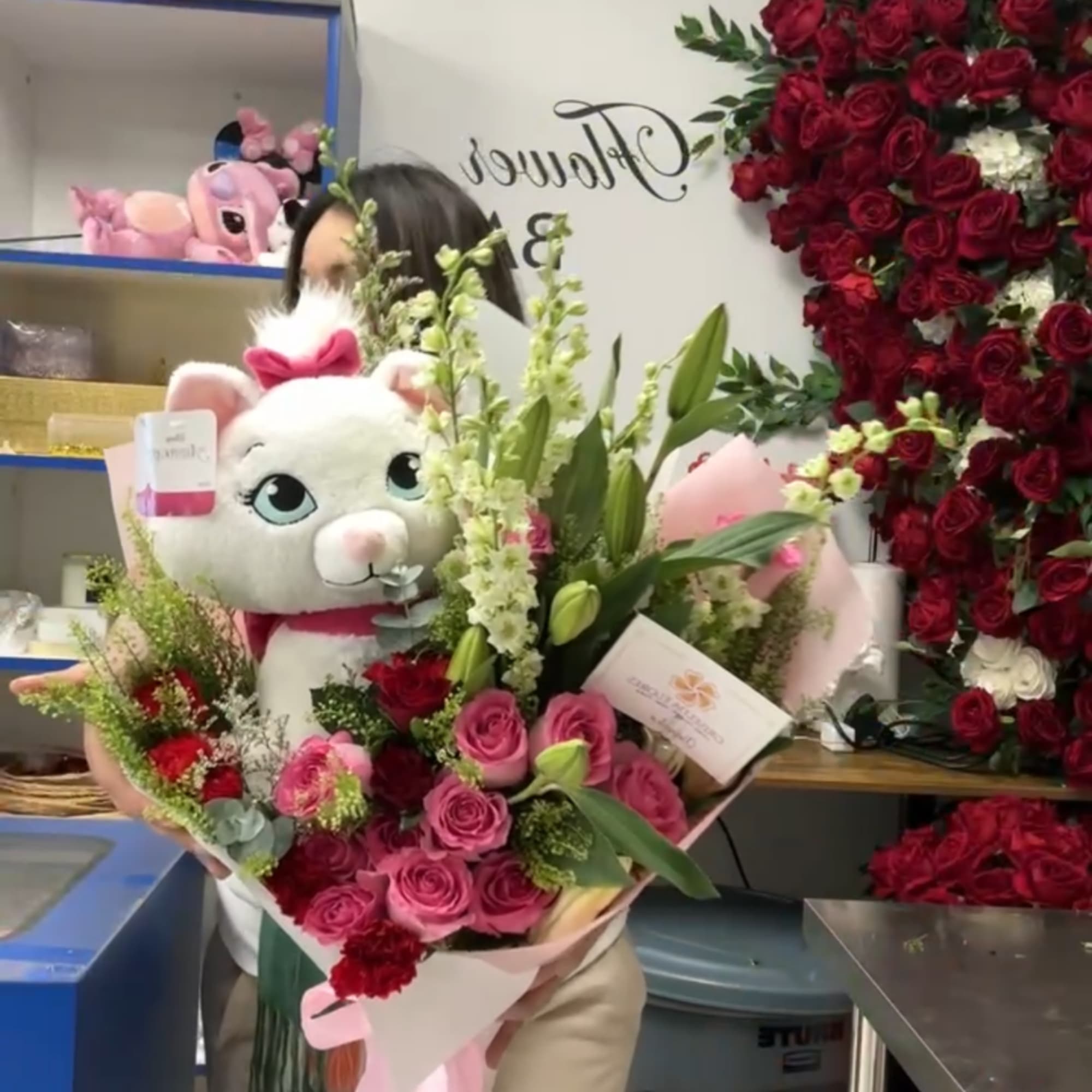 Bouquet of pink and red roses with a plush white teddy bear