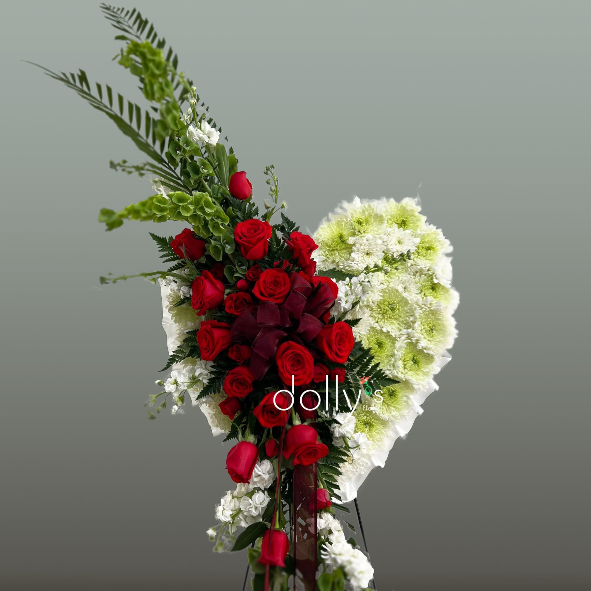 This floral design pairs red roses with white and pale green chrysanthemums