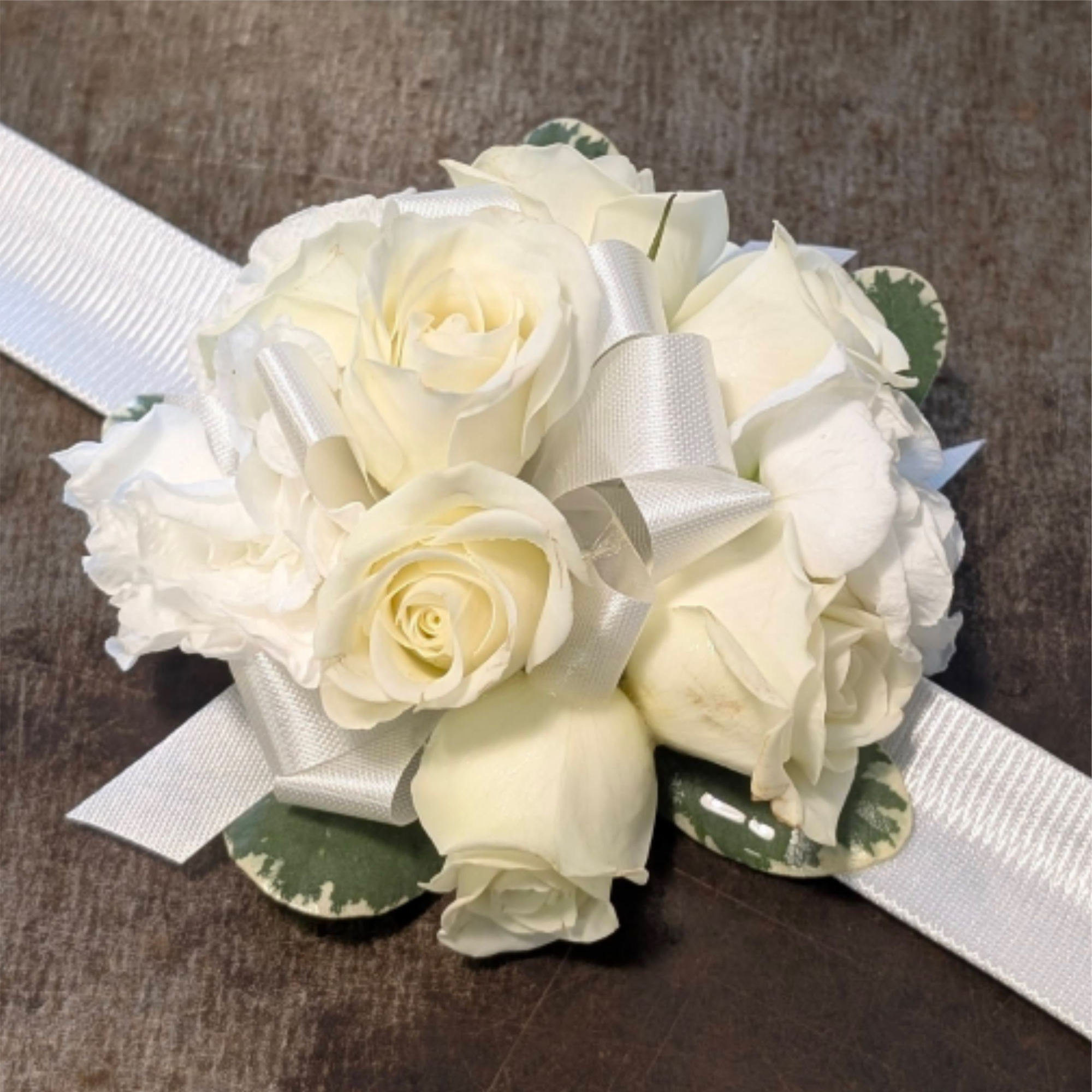 Tight cluster of white roses with ribbon color accent on a snap