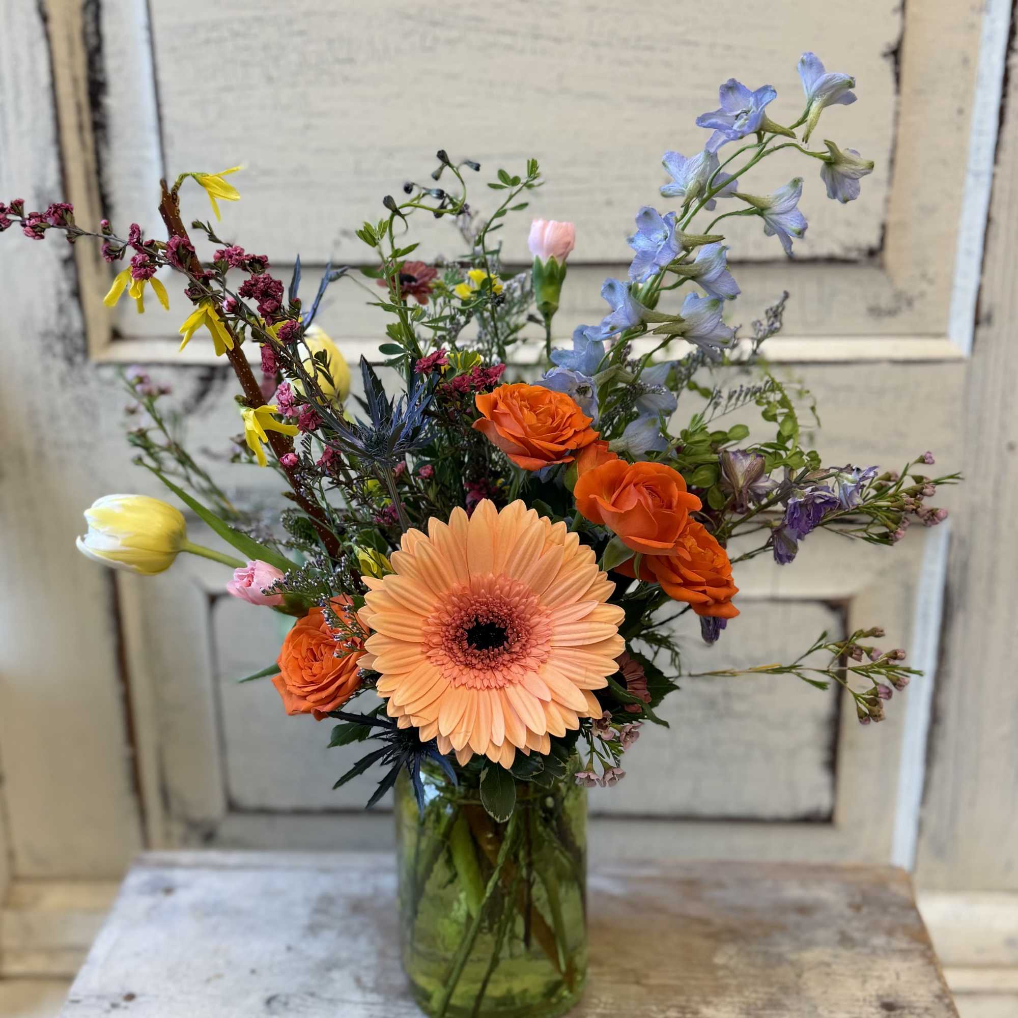 A small colored glass vase or jar holds a just right assortment