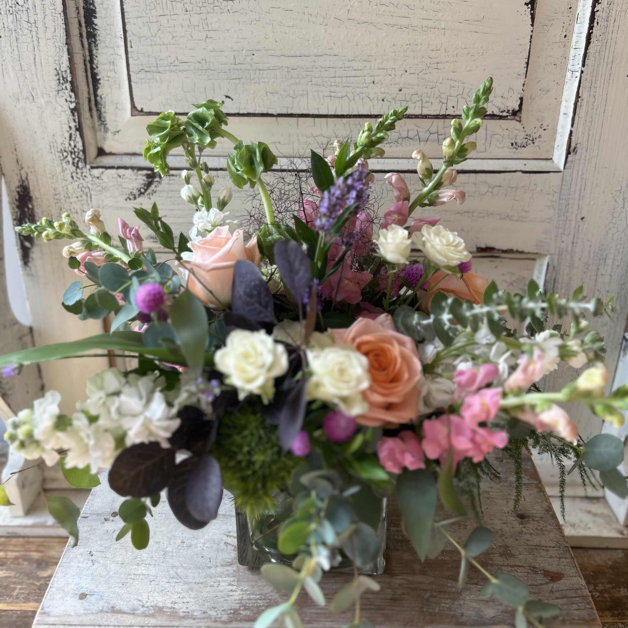 Mixed bouquet in a glass vase with pink, peach, and white flowers