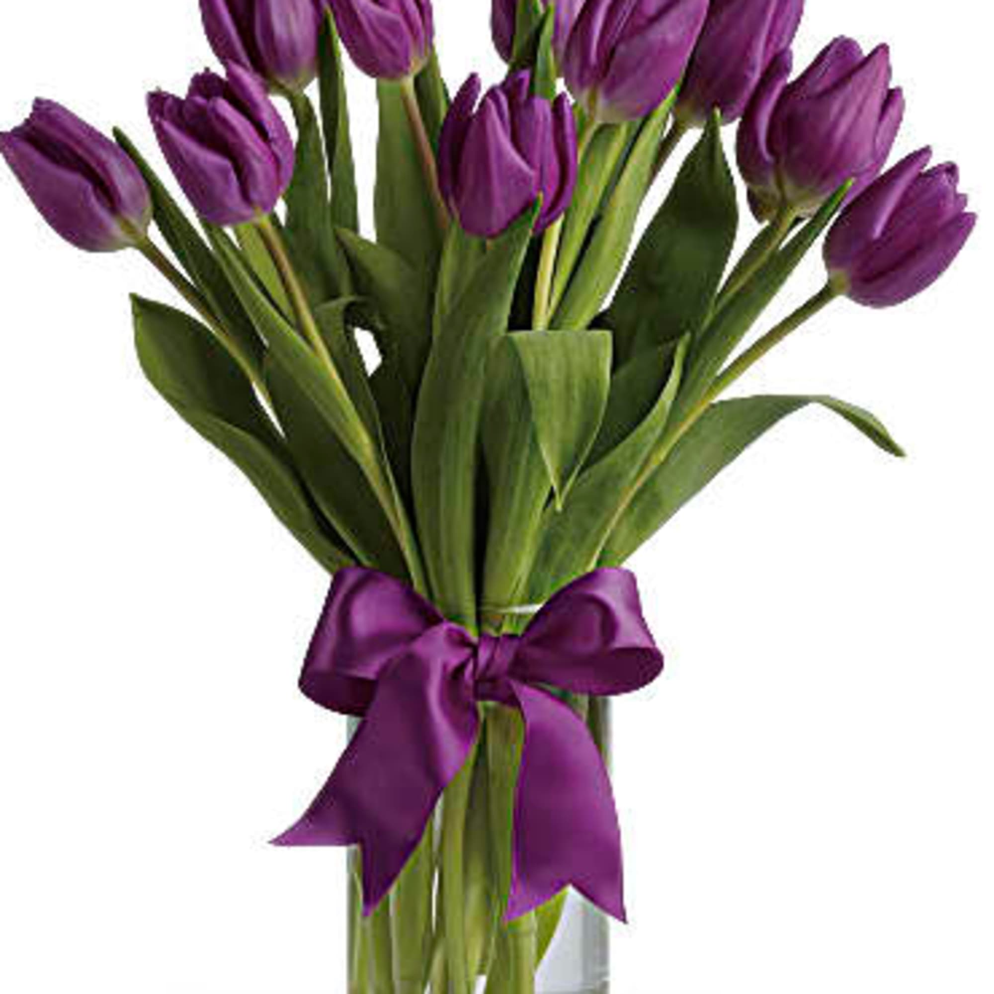 Purple tulips in a clear glass vase tied with a purple ribbon
