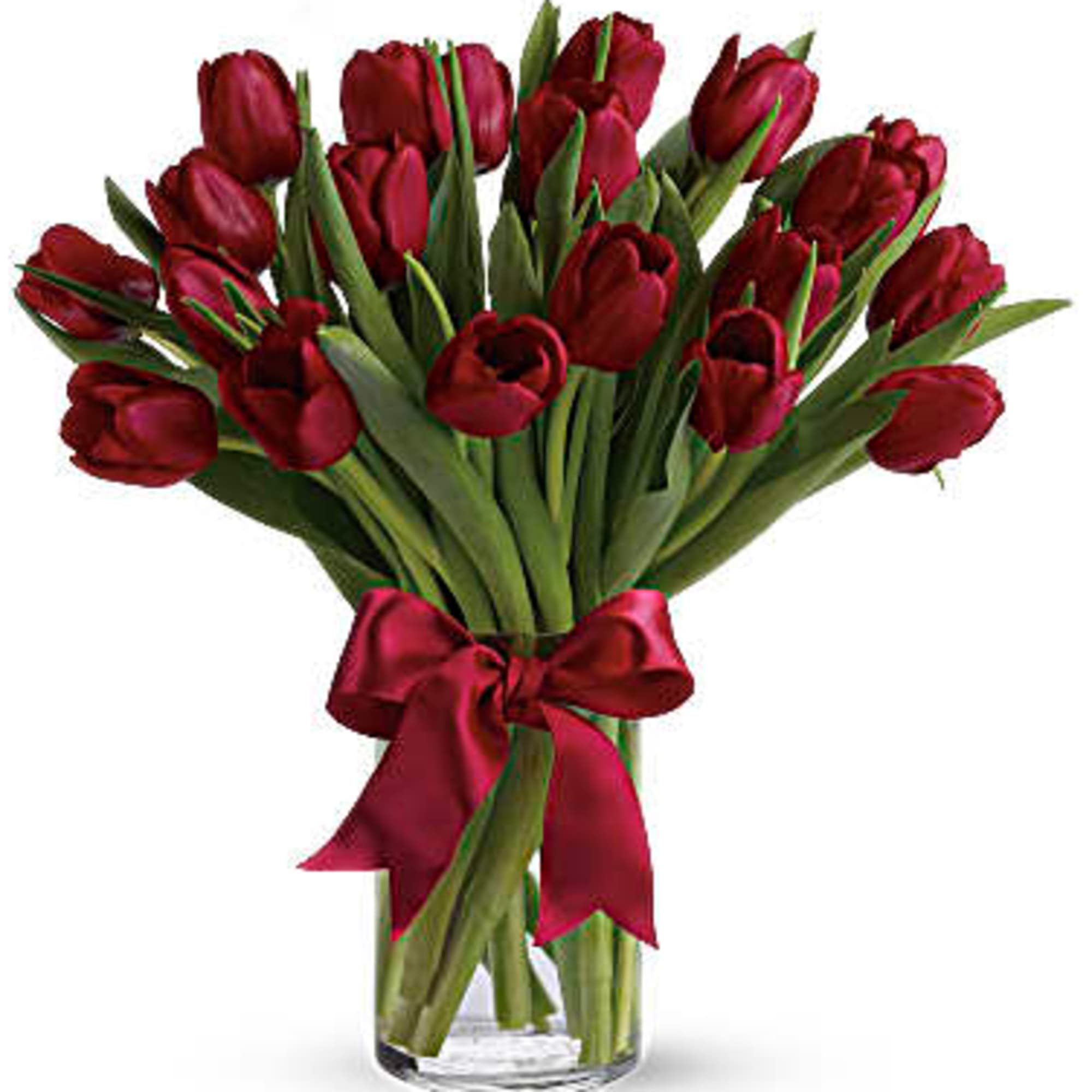 Bouquet of red tulips tied with a red ribbon in a clear vase