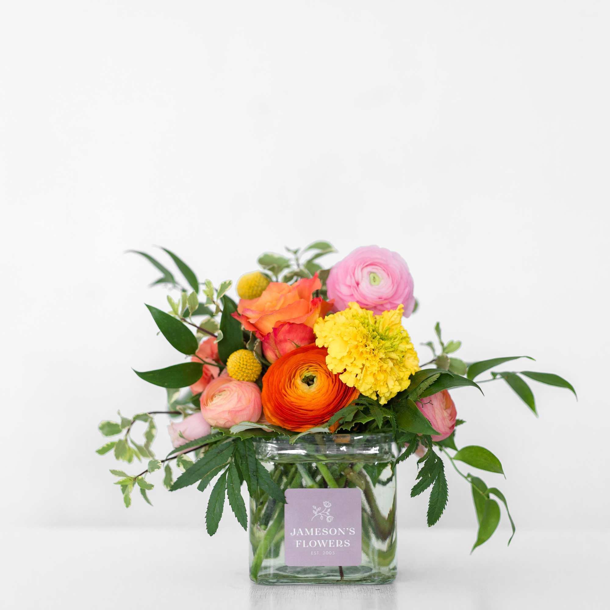 Colorful mixed bouquet in a square glass vase