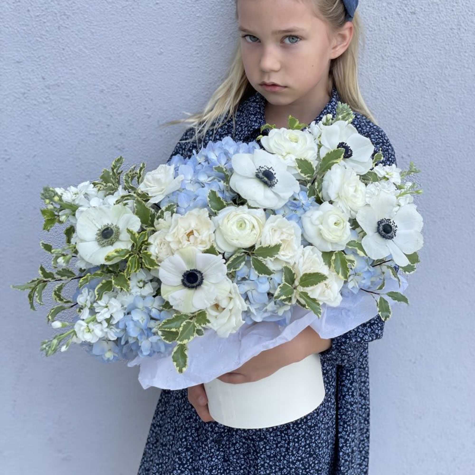 Girl holding a large bouquet of white and pale blue flowers