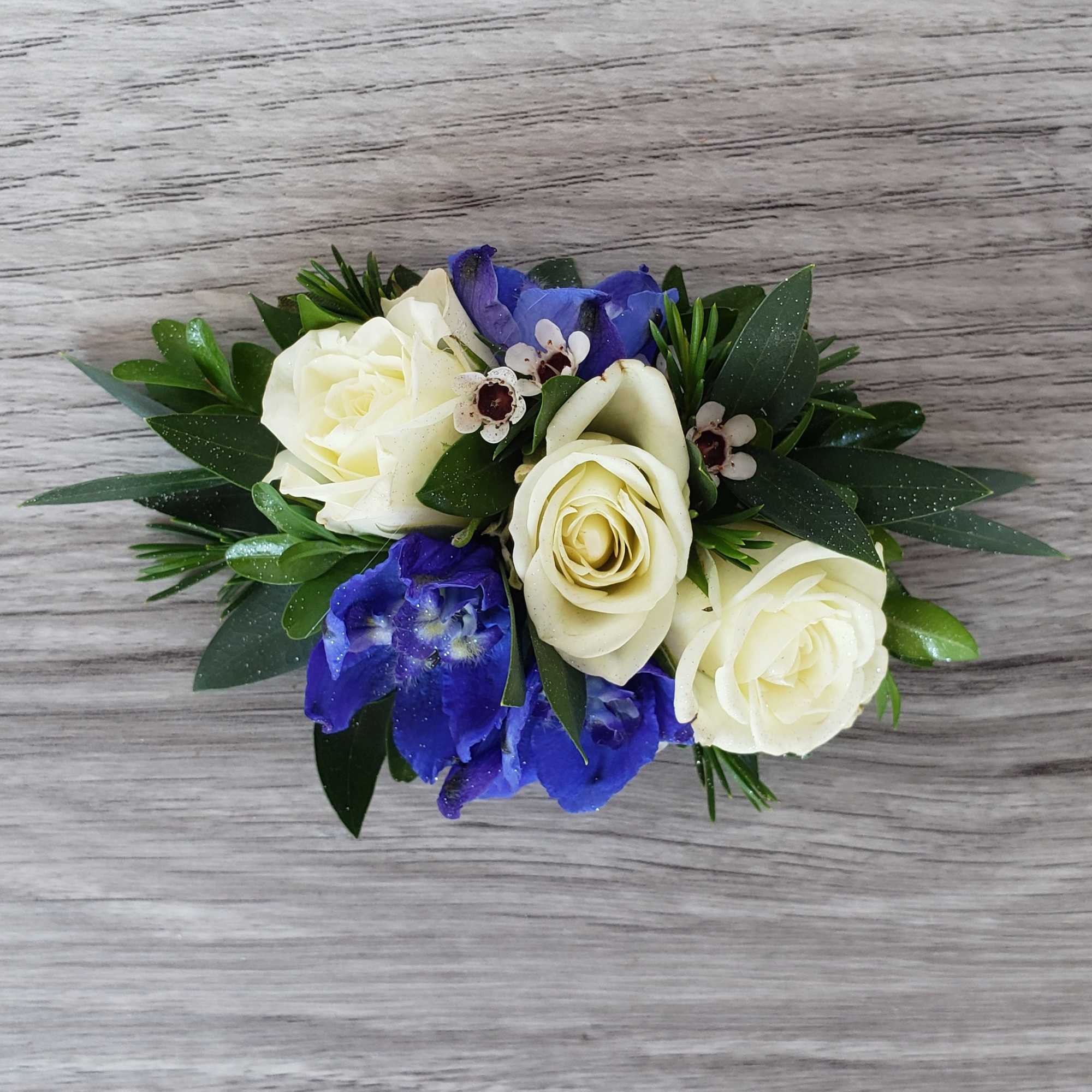 White roses and blue flowers in a low arrangement