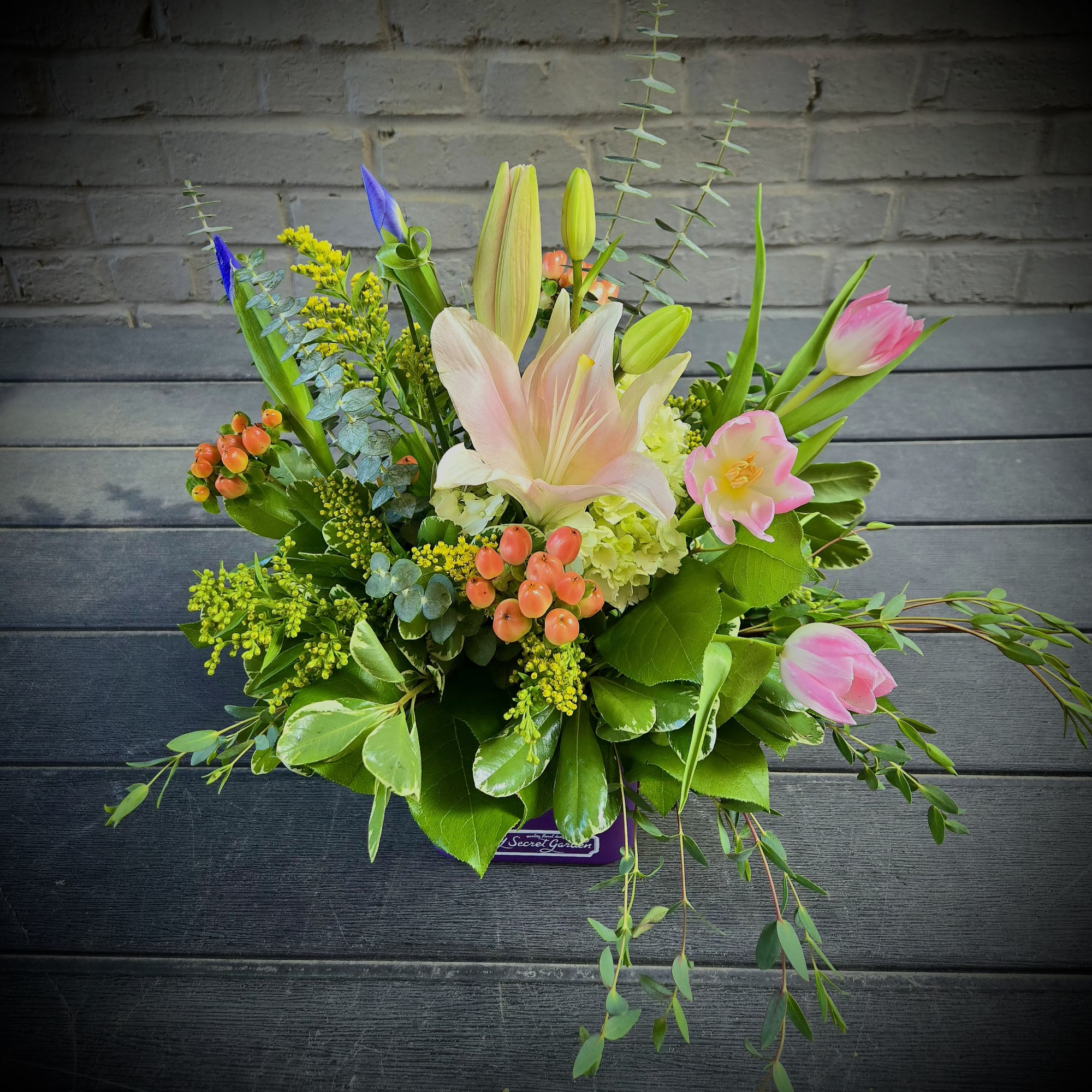 A cluster of soft pink lilies and tulips opens like a gentle