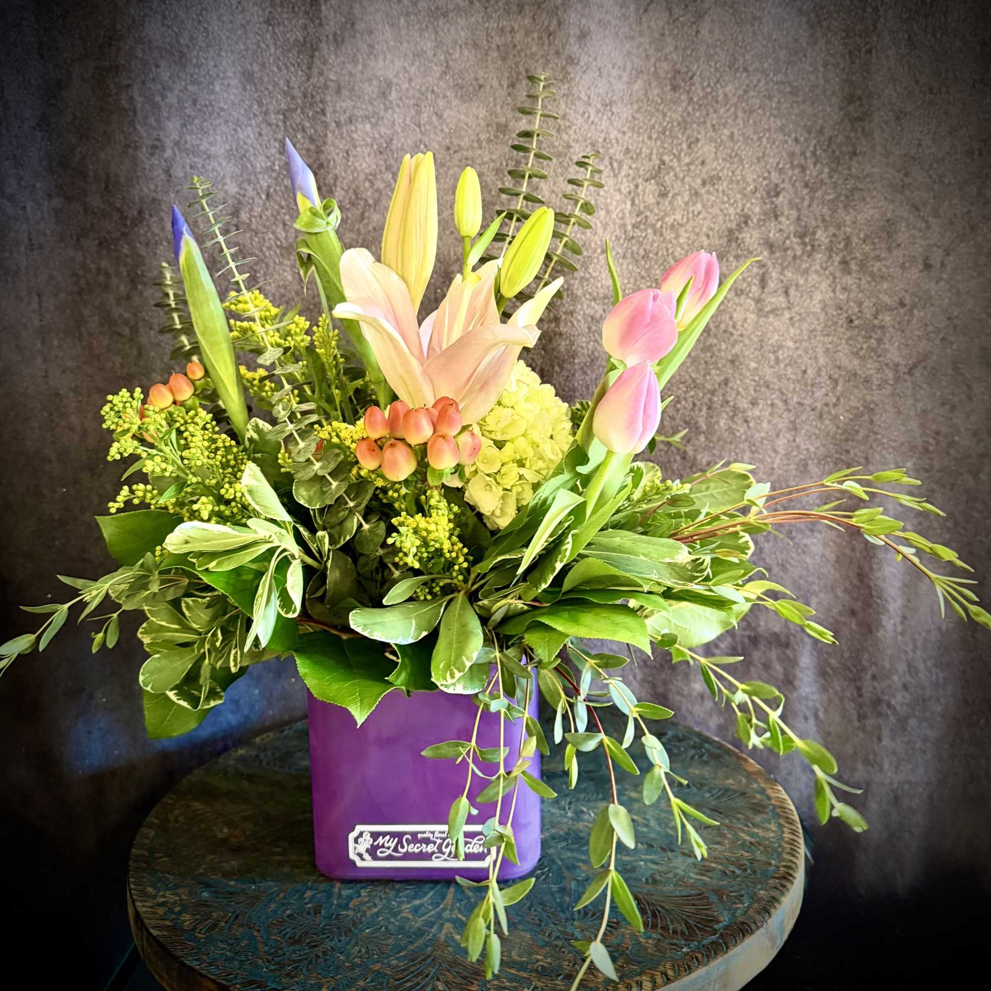 A cluster of soft pink lilies and tulips opens like a gentle