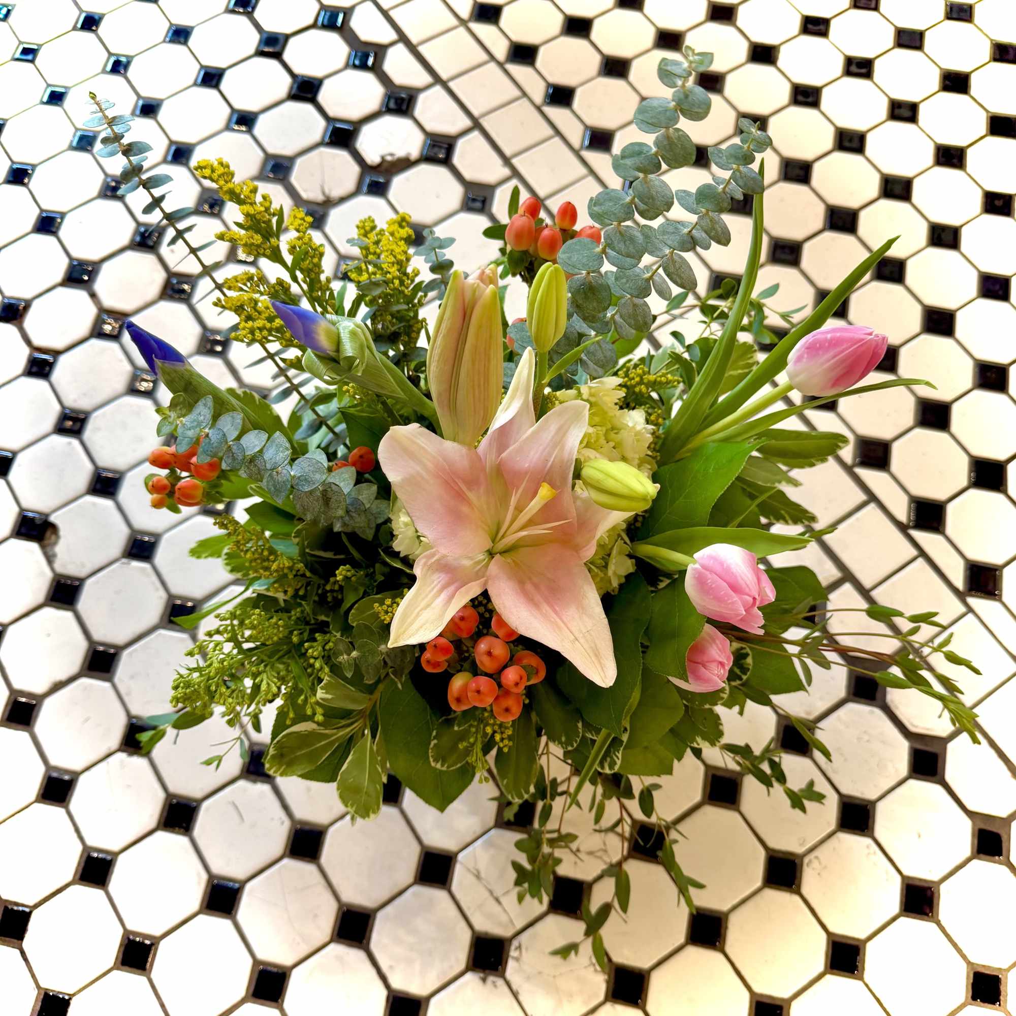A cluster of soft pink lilies and tulips opens like a gentle