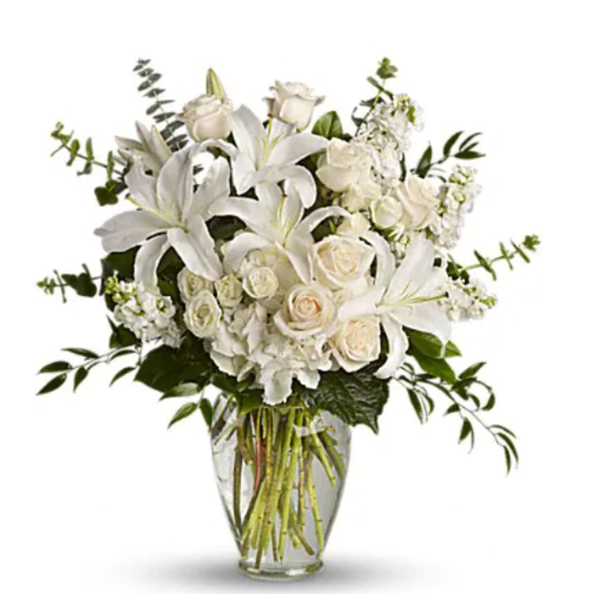 White lilies and roses arranged in a clear glass vase