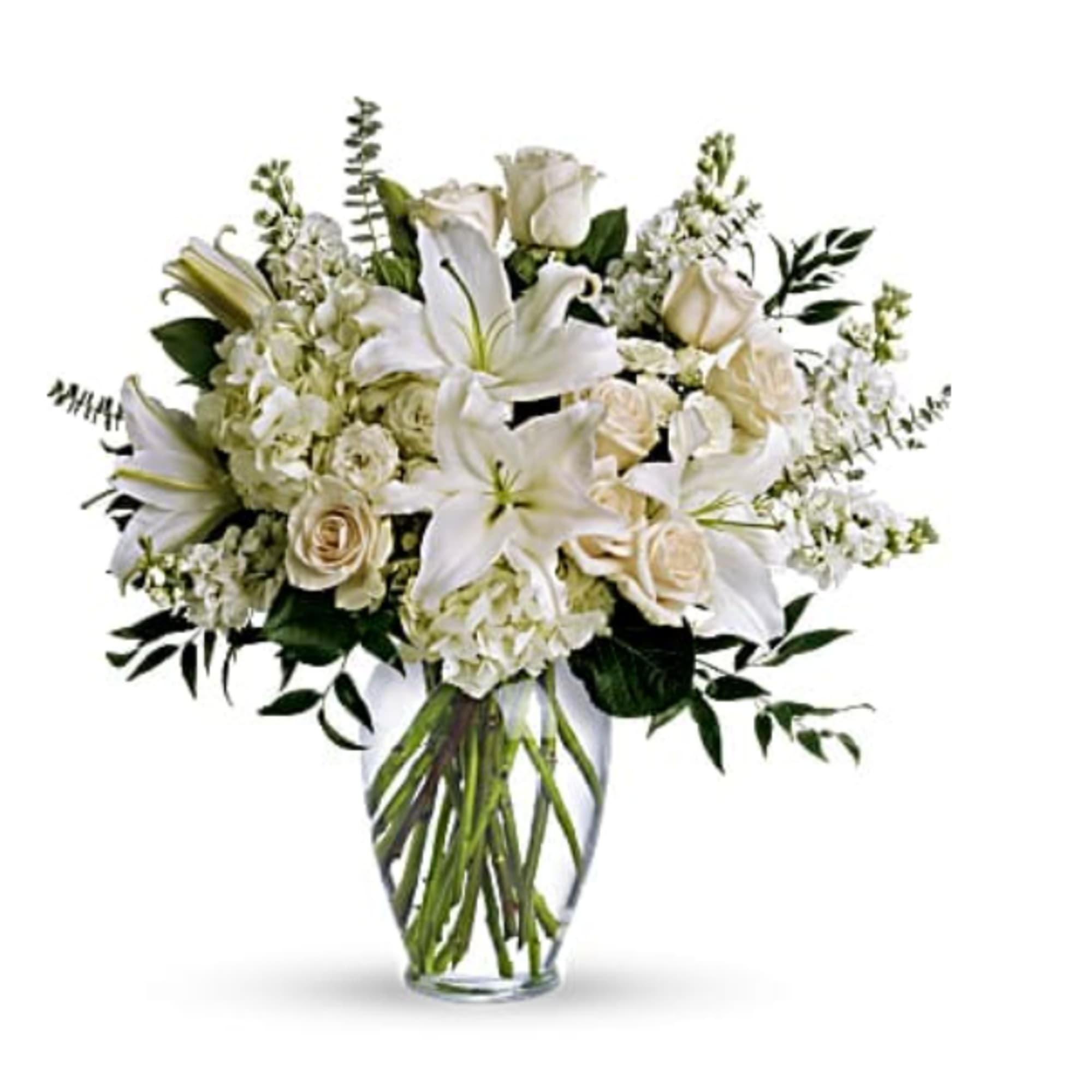 White lilies and roses arranged in a clear glass vase