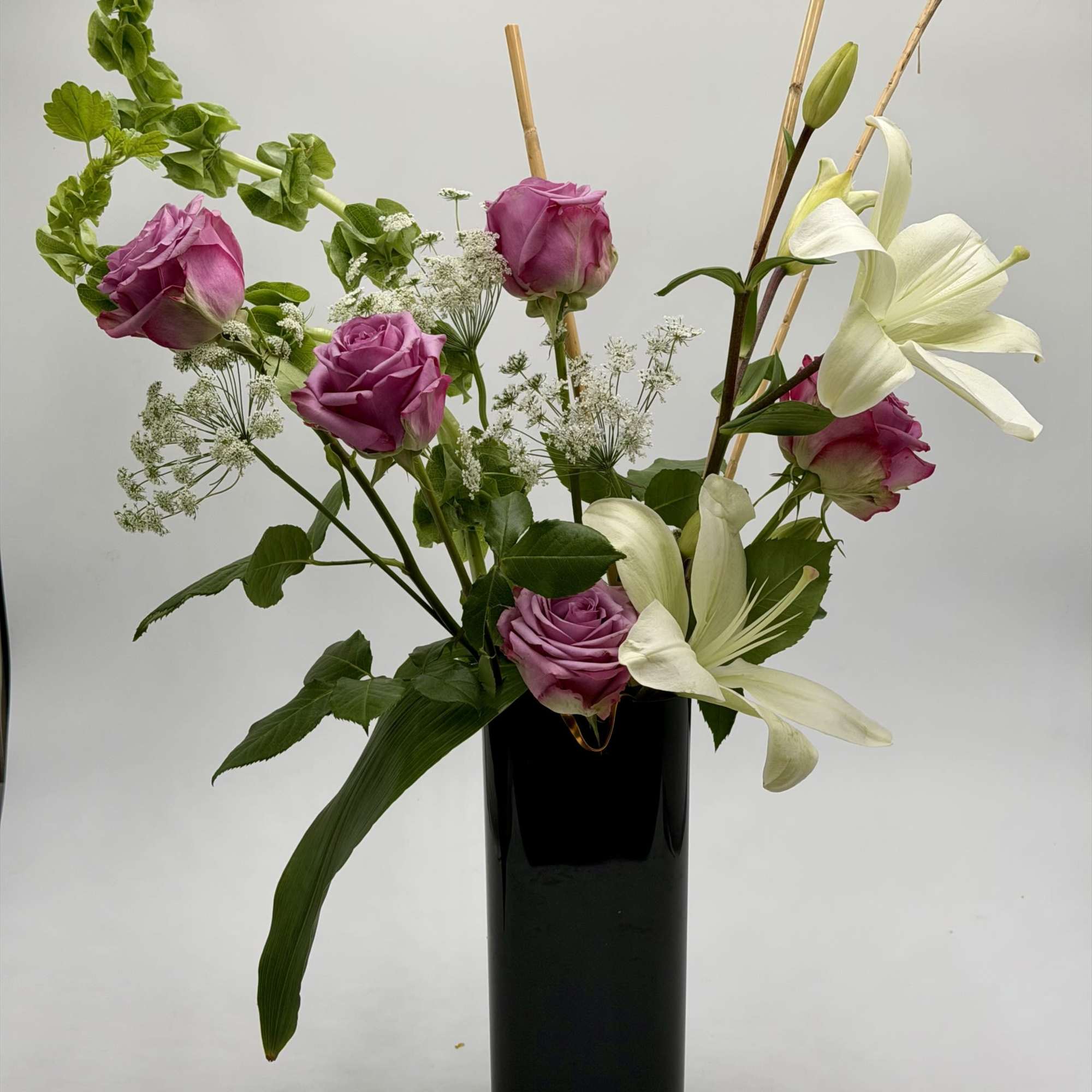 A graceful blend of lavender roses and elegant white lilies creates a