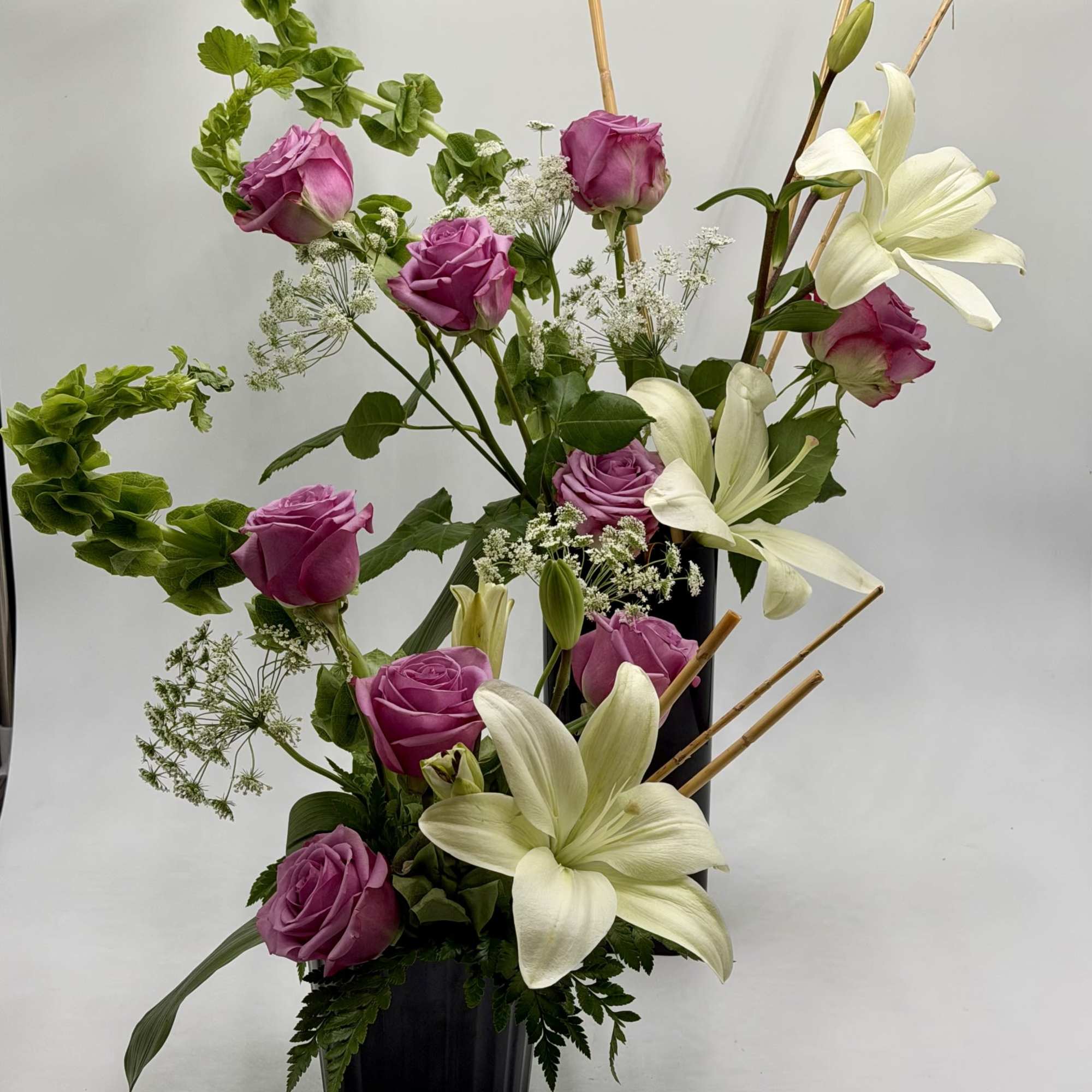A graceful blend of lavender roses and elegant white lilies creates a