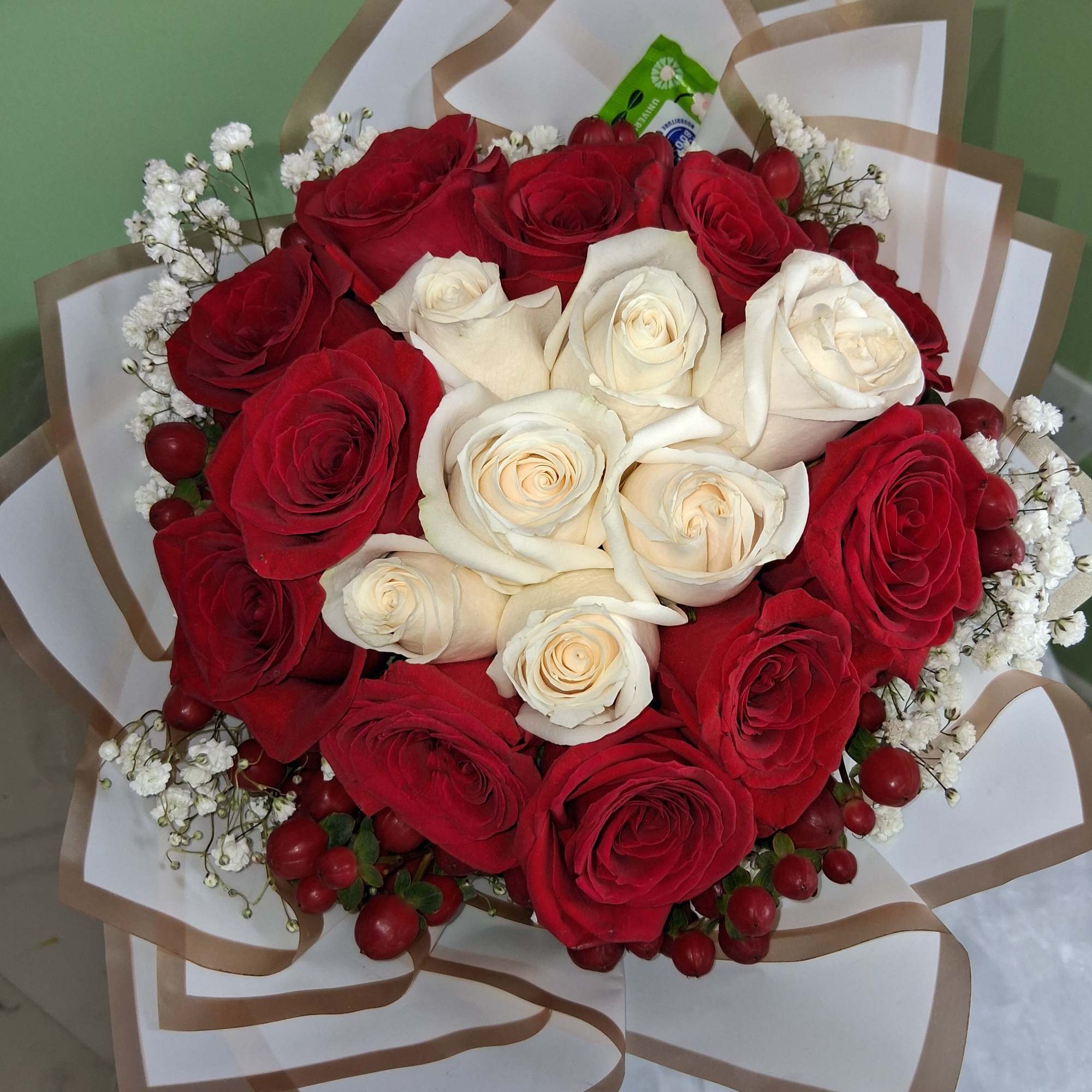 A striking ring of deep red roses encircles a creamy white heart