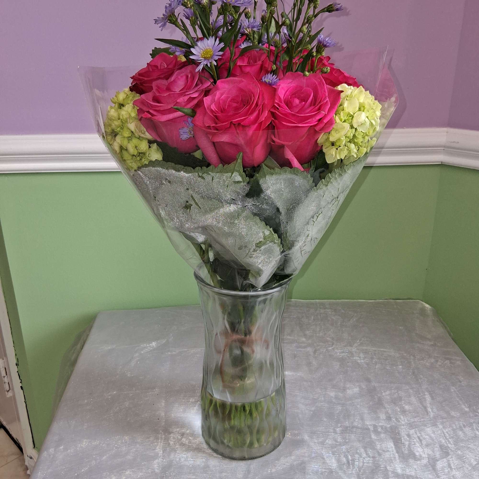 Vivid hot pink roses take center stage in this romantic flower arrangement